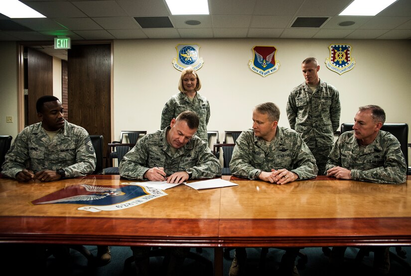 Colonel Richard McComb, Joint Base Charleston commander, and Col. Darren Hartford, 437th Airlift Wing commander, sign the DUI Battle Plan March 13, 2013, while Chief Master Sgt. Avery Jones, 628th Mission Support Group superintendent, Senior Master Sgt. Michelle McMeekin, 628th Force Support Squadron career assistant advisor, Maj. Michel Daniel, 628th Medical Group director of psychological health, and Chief Master Sgt. Larry Williams, 437th Airlift Wing command chief, attend the signing. The DUI Battle Plan is a comprehensive campaign aimed at reducing drunk driving and reinforcing positive life choices.  The battle plan was modeled after a campaign launched at Travis Air Force Base, Calif.  The plan reduced DUIs by 42 percent after only one year of implementation at Travis. Locally, the campaign will be officially kicked off on April 1. (U.S. Air Force photo/ Senior Airman Dennis Sloan)