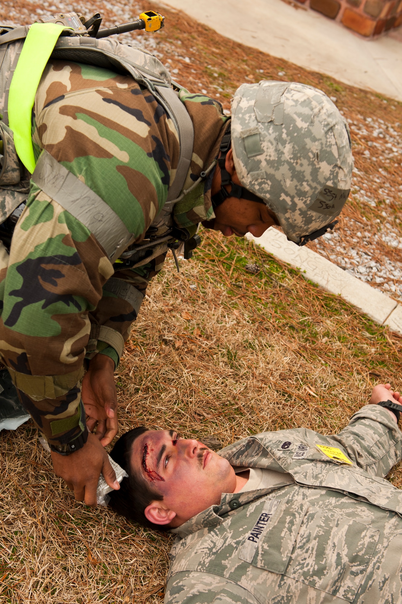 Staff Sgt. Eric Murphy, 8th Security Forces Squadron, treats the head wound of Senior Airman Ian Painter, 8th Fighter Wing role-player, during exercise Beverly Midnight 13-2 at Kunsan Air Base, Republic of Korea, March 19, 2013. The simulated injury adds a sense of realism to the training scenario. (U.S. Air Force photo by Staff Sgt. Jonathan Fowler/Released)