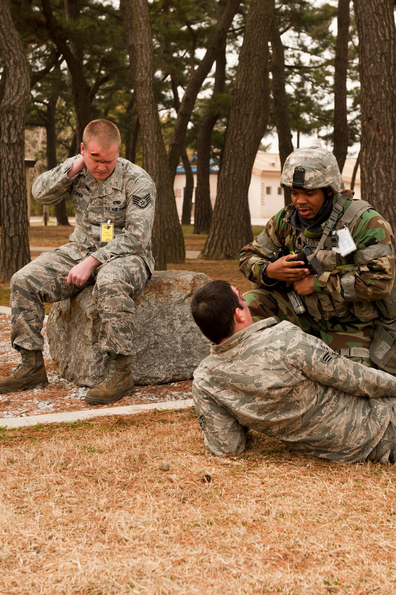 Staff Sgt. Eric Murphy (right), 8th Security Forces Squadron, speaks with Staff Sgt. Michael O’Brien and Senior Airman Ian Painter, 8th Fighter Wing role-players, following a simulated attack at Kunsan Air Base, Republic of Korea, March 19, 2013. Murphy was assessing both role-players to determine what types of (simulated) injuries they had sustained following the mortar attack. (U.S. Air Force photo by Staff Sgt. Jonathan Fowler/Released)