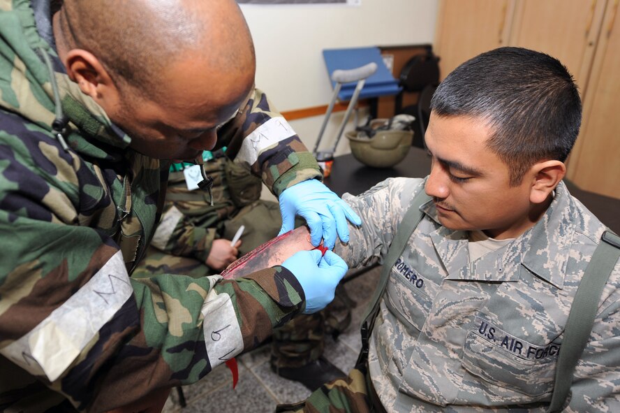 Tech. Sgt. Theodonte Wiseman (left), 51st Medical Squadron bioenvironmental engineering technician, applies a fake wound on Staff Sgt. Erick Romero, 51st Communications Squadron member, for a simulated mass casualty during Beverly Midnight 13-02 at Osan Air Base, Republic of Korea, March 19, 2013. During the week-long exercise, Osan Airmen will be tested on their ability to utilize their chemical, biological, radiological and nuclear training, as well as administer self-aid and buddy-care during a contingency. (U.S. Air Force photo/Senior Airman Alexis Siekert)