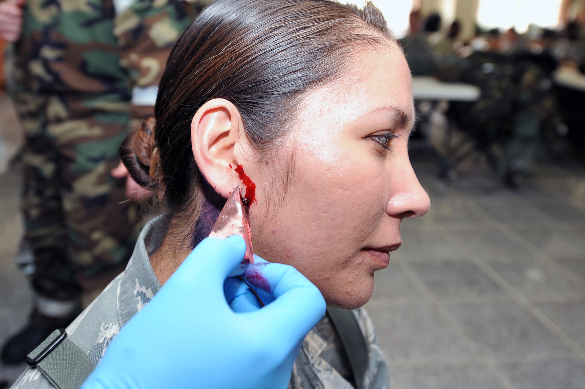 Senior Airman Melissa Higa, 51st Munitions Squadron armament back shop technician, has fake blood applied to her ear to make it look like she suffered a head and neck injury in a simulated attack during an Operational Readiness Exercise Beverly Midnight 13-02 at Osan Air Base, Republic of Korea, March 19, 2013. This is Osan’s third simulated wartime contingency exercise in 2013 that will test the base’s ability to defend and execute the mission in a heightened state of readiness. (U.S. Air Force photo/Senior Airman Alexis Siekert)