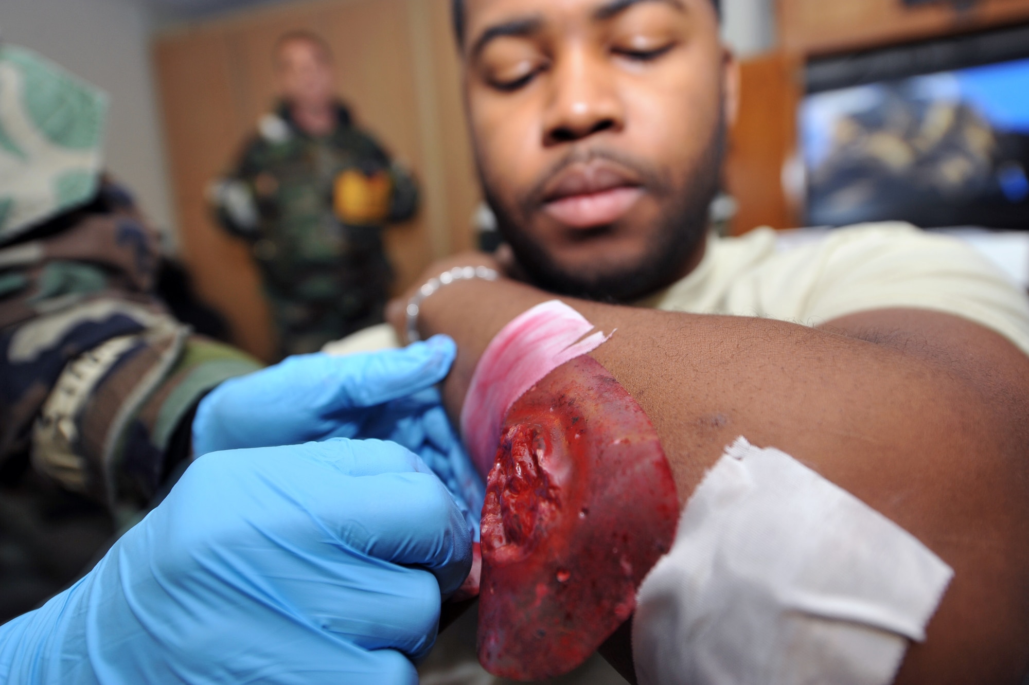 Airman 1st Class Johari Foshee, 51st Logistics Readiness Squadron travel management office member, has a fake wound applied to his arm to make it look like he was injured in a simulated attack during Operational Readiness Exercise Beverly Midnight 13-02 at Osan Air Base, Republic of Korea, March 19, 2013. Airmen from the 51st Medical Group apply moulage to mock victims every exercise to help Airmen and medical professionals better learn how to give proper medical treatment. (U.S. Air Force photo/Senior Airman Alexis Siekert)