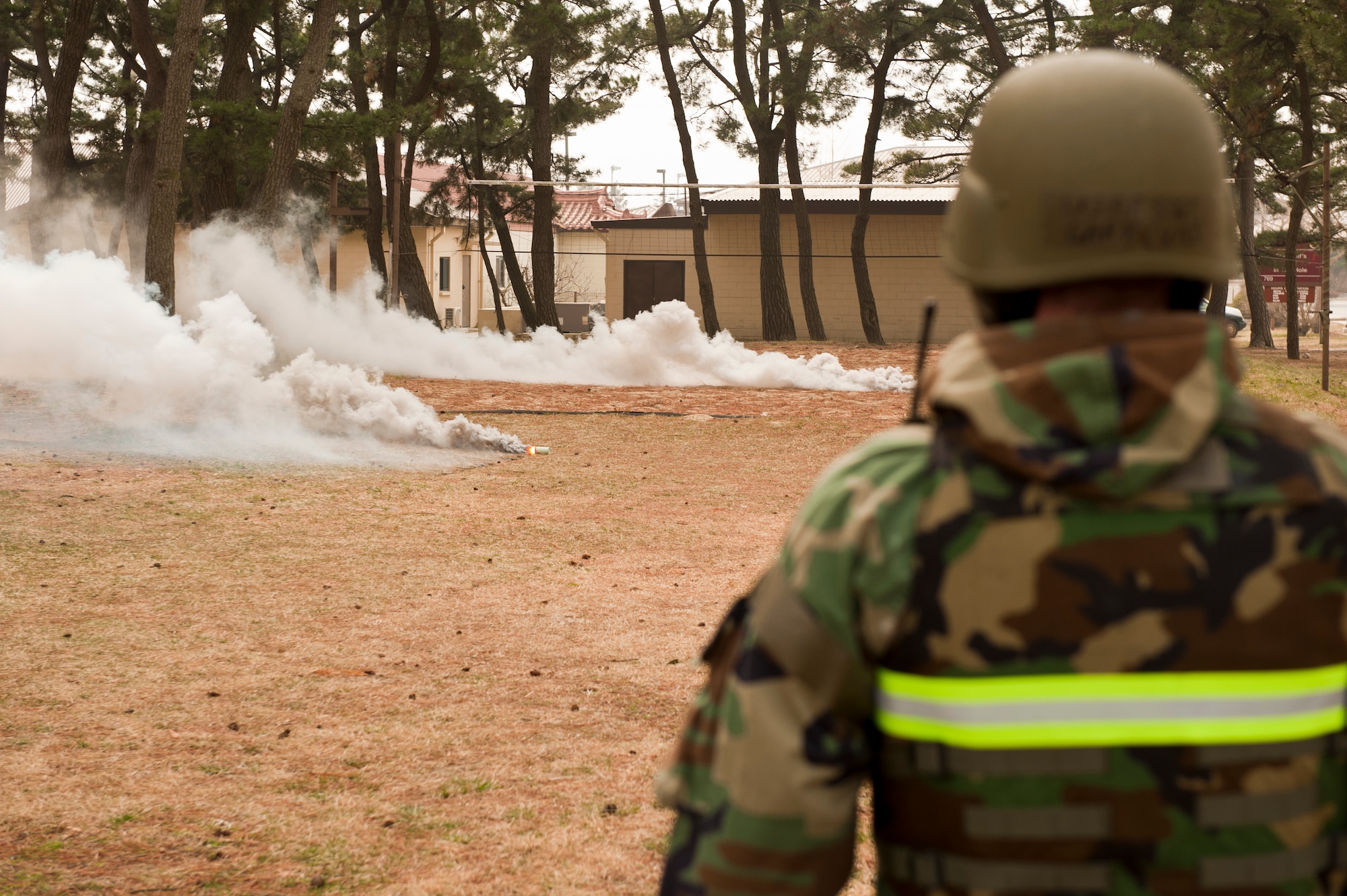 Staff Sgt. Gary Lund, 8th Fighter Wing ground safety, watches as smoke grenades go off during exercise Beverly Midnight 13-2 at Kunsan Air Base, Republic of Korea, March 19, 2013. The scenario is designed to simulate the smoke from a mortar attack. (U.S. Air Force photo by Staff Sgt. Jonathan Fowler/Released)
