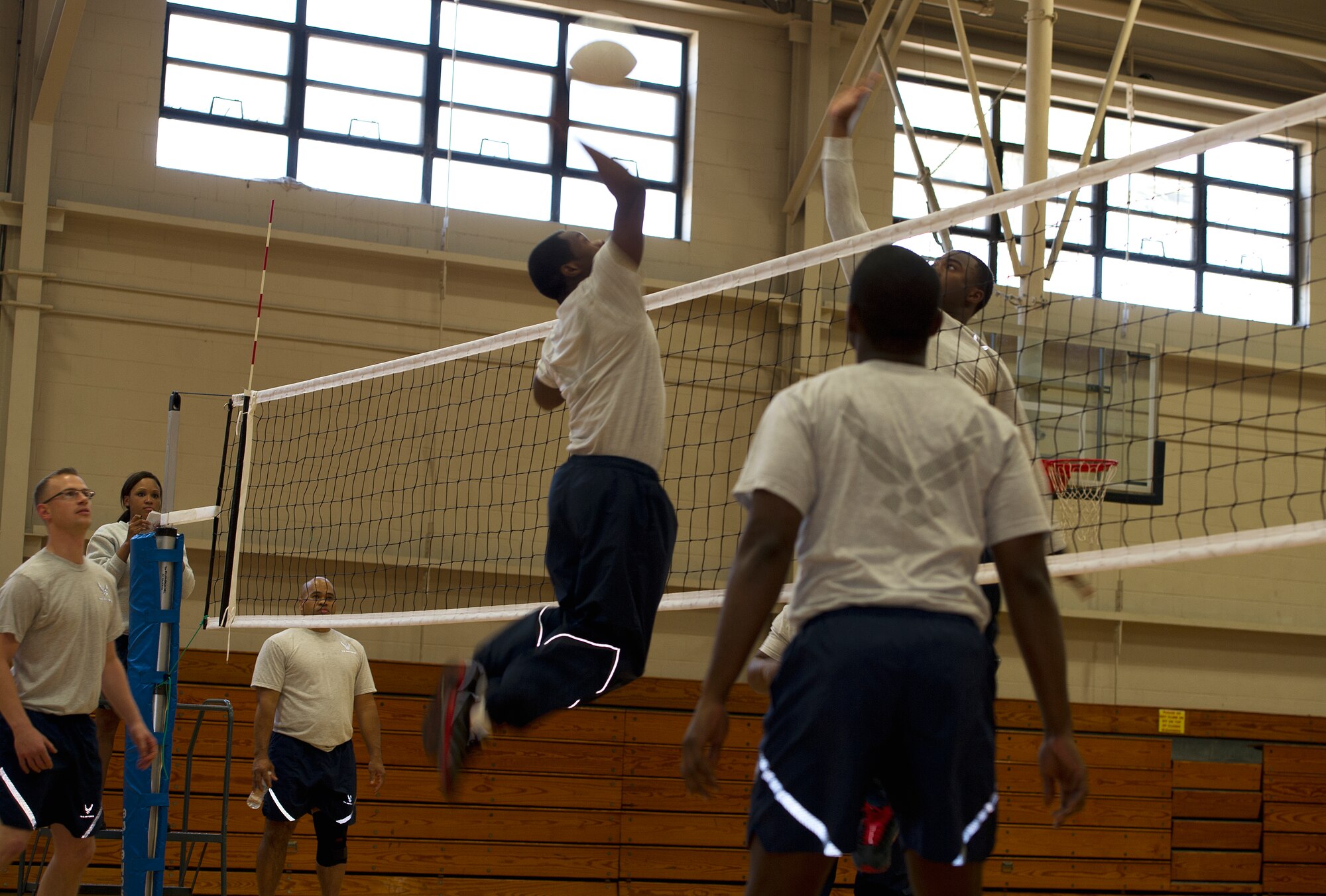 Airmen from the 628th Air Base Wing staff agencies jump to spike a volleyball during a match as part of a Wingman day competition March 14, 2013, at the Fitness Center on Joint Base Charleston, S.C. Wingman Day, a quarterly event, allows Airmen to take a break from their daily duties and come together to focus on various key topics that impact their personal and professional lives. (U.S. Air Force/Staff Sgt. Rasheen Douglas)