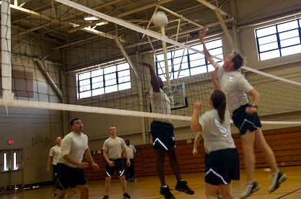 Airmen, from the 628th Air Base Wing staff agencies, jump to spike the ball during a game of volleyball between company grade and noncommissioned officers during Wingman Day March 14, 2013, at the Fitness Center on Joint Base Charleston – Air Base, S.C. Wingman Day, a quarterly event, allows Airmen to take a break from their daily duties and come together to focus on various key topics that impact their personal and professional lives. (U.S. Air Force/Staff Sgt. Rasheen Douglas)