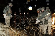 8th Security Forces Squadron members, place concertina wire around the perimeter of a building during exercise Beverly Midnight 13-2 at Kunsan Air Base, Republic of Korea, March 17, 2013. The exercise was designed to sharpen U.S. Air Force and Republic of Korea air force integration and combat capabilities. (U.S. Air Force photo by Senior Airman Marcus Morris/Released) 