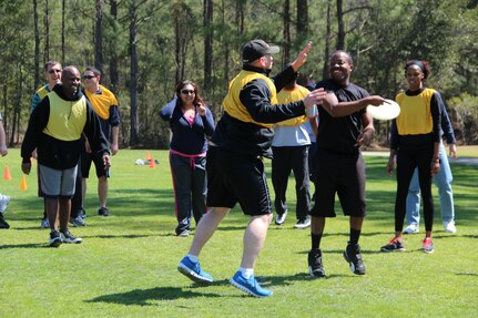Senior Airman Darius Session, 628th Communication Squadron cyber systems apprentice, attempts to throw a Frisbee while Chief Master Sgt. Michael Gibson, 628th CS, tries to block his pass during Wingman Day March 14, 2013, at Joint Base Charleston – Air Base Fitness Center. Wingman Day provides an opportunity for JB Base Charleston units to take a well-needed break from their everyday routines and focus on what is truly important in this life: each other (Courtesy photo)