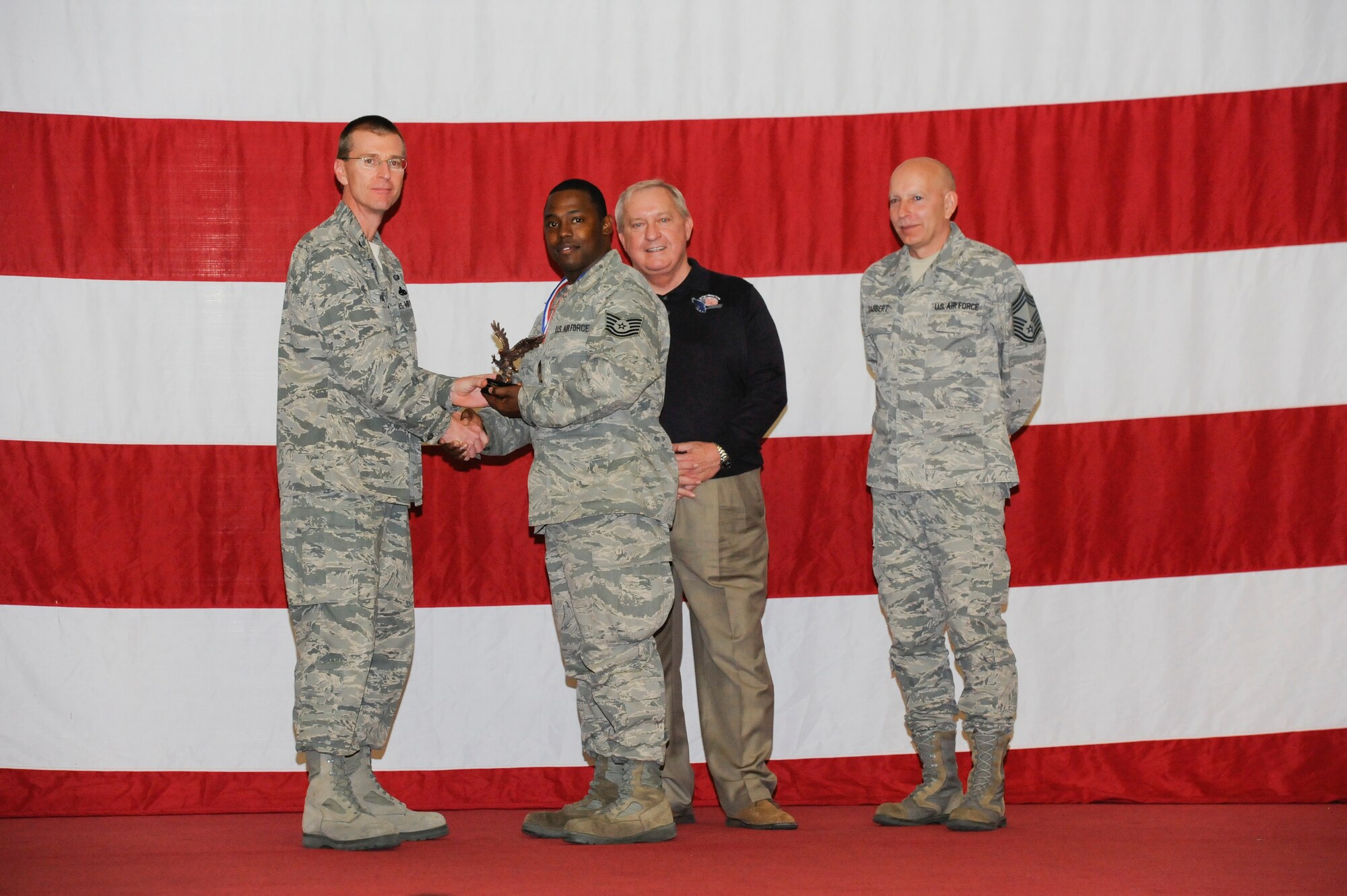 Tech. Sgt. Terrance Townsend earns the ACC Outstanding Munitions Supervisor Award during the 2012 Maintenance Professionals of the Year ceremony March 15 from Col. Curtis Hafer, 325th Maintenance Group commander, retired Chief Master Sgt. of the Air Force James Binnicker and Chief Master Sgt. Terry Gabbert, 325th Maintenance Group superintendent. (U.S Air Force photo by Chris Cokeing)