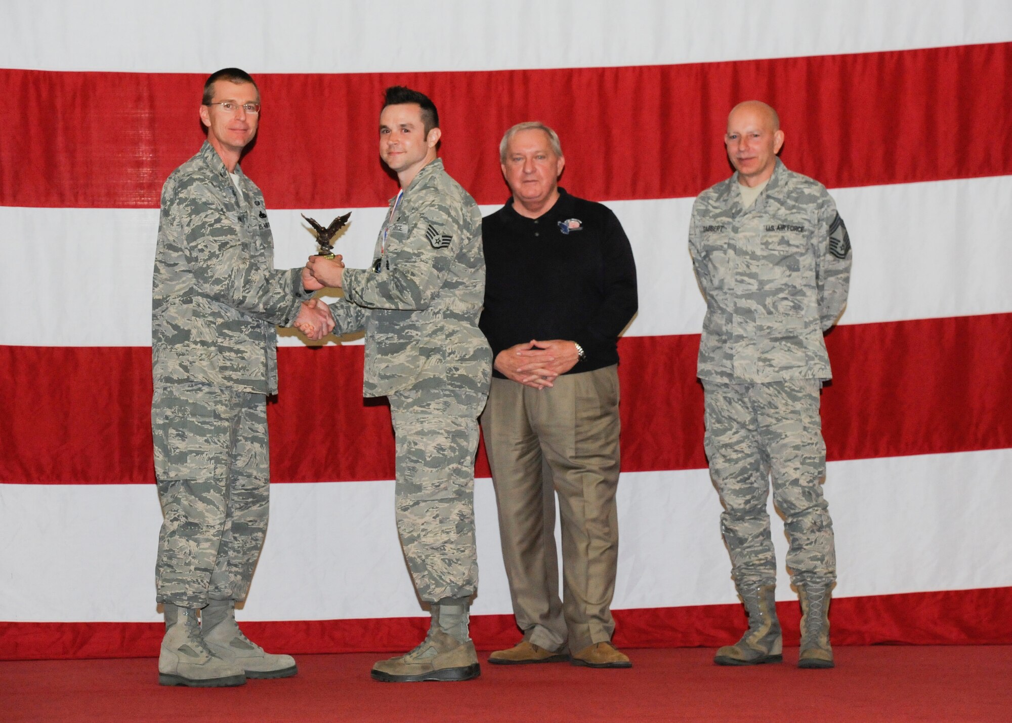 Staff Sgt. Christopher Cosby earns the ACC Outstanding Armament Supervisor Award during the 2012 Maintenance Professionals of the Year ceremony March 15 from Col. Curtis Hafer, 325th Maintenance Group commander, retired Chief Master Sgt. of the Air Force James Binnicker and Chief Master Sgt. Terry Gabbert, 325th Maintenance Group superintendent. (U.S Air Force photo by Chris Cokeing)