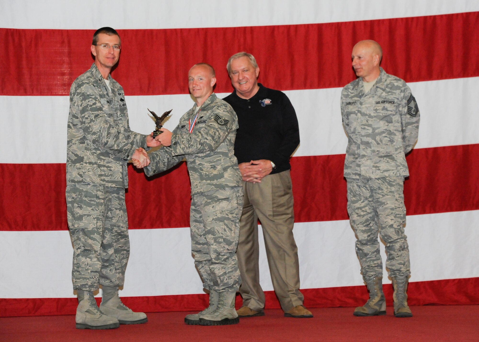 Staff Sgt. Charles Chupp earns the ACC Outstanding Armament Technician Award during the 2012 Maintenance Professionals of the Year ceremony March 15 from Col. Curtis Hafer, 325th Maintenance Group commander, retired Chief Master Sgt. of the Air Force James Binnicker and Chief Master Sgt. Terry Gabbert, 325th Maintenance Group superintendent. (U.S Air Force photo by Chris Cokeing)