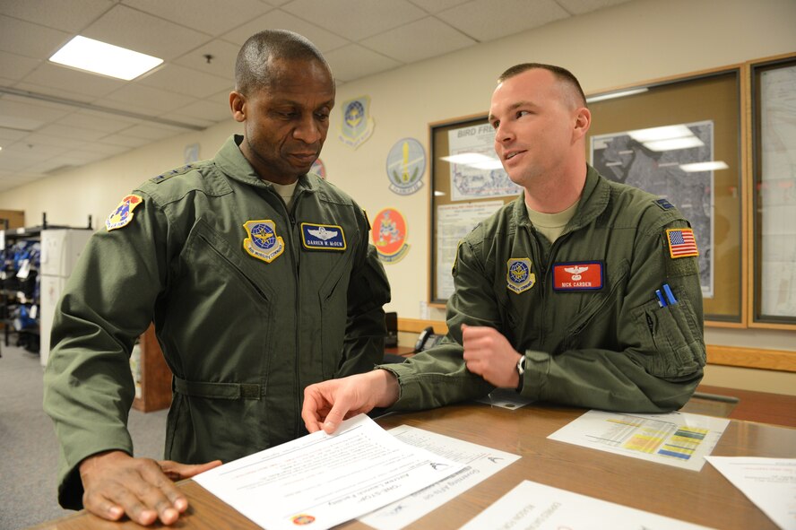 Capt. Nick Carden, 62nd Operations Group Readiness Flight Commander (right), briefs Lt. Gen. Darren McDew, 18th Air Force commander, on the Post Mission Review process March 14, 2013 at Joint Base Lewis-McChord, Wash. The 62nd OG's PMR process ensures accurate and timely crew data verification for flight crews. (U.S. Air Force photo/Tech. Sgt. Sean Tobin)
