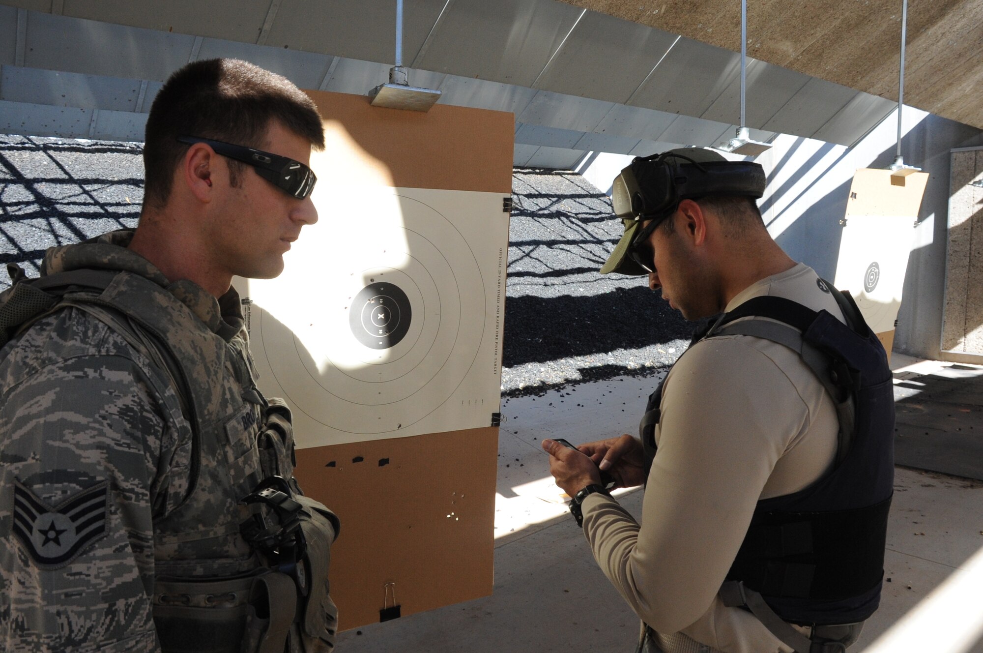 Staff Sgt. Paul Brow checks his marksmanship with Gabriel Vasquez, a SWAT officer, at a law enforcement shooting range March 14, 2013. The exercise was a part of a joint exercise with an Air Force Explosive Ordinance Disposal team from the 366th Training Squadron. (U.S. Air Force photo by Airman 1st Class Jelani Gibson)