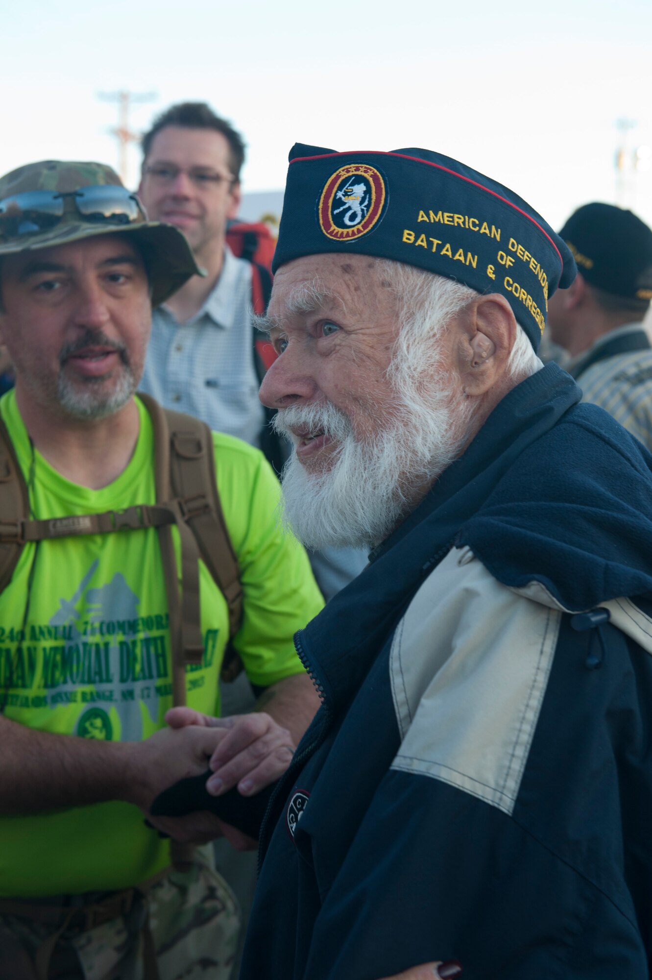 Oscar Leonard a World War ll survivor, stands at the start line and shakes hands with the participants in the 24th annual Bataan Memorial Death March at White Sands Missile Range, N.M., March 17. Over 5,800 people came to honor more than 76,000 Prisoners Of War/Missing In Action from Bataan and Corregidor during World War ll. The 26.2-mile course starts on WSMR, enters hilly terrain and finishes through sandy desert trails, with elevation ranging from 4,100-5,300 feet. This year 13 veterans from World War ll attended the event. (U.S. Air Force photo by Airman Leah Murray/Released)