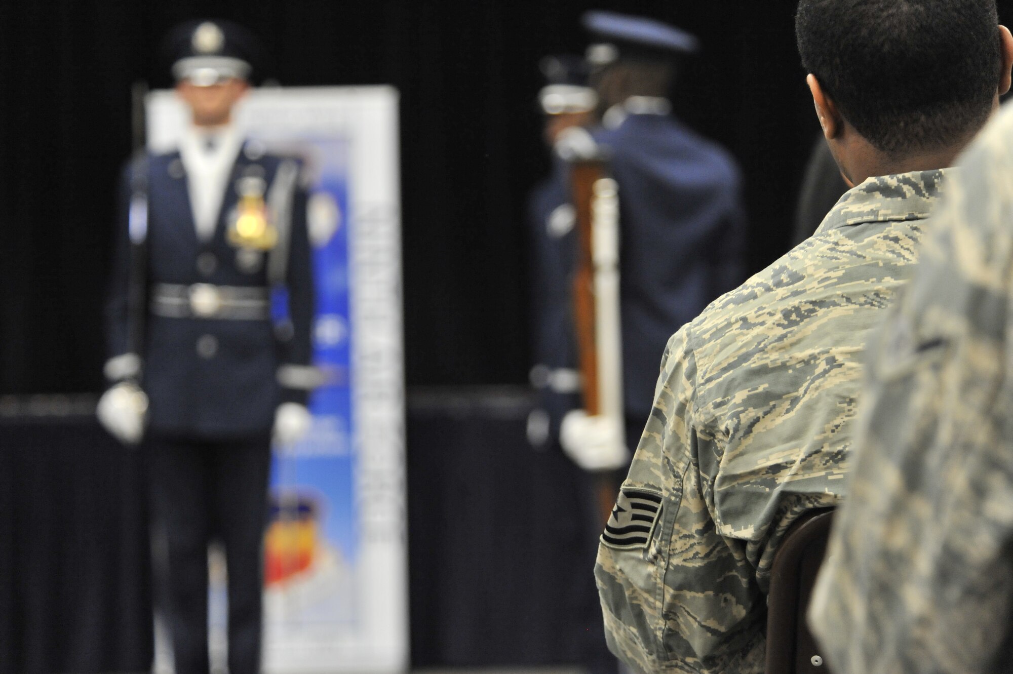 A U.S. Air Force Tech. Sgt. watches a performance of the USAF Honor Guard Drill Team during a Leadership Friday event at the Shaw Air Force Base Community Activity Center, S.C., March 15, 2013. As one of the Air Force's oldest organizations, the Honor Guard continues to serve the Chief of Staff of the Air Force as the face of the Air Force to the American and global public. Airmen of every enlisted rank and career field, both company and field grade officers, compete to serve in the Honor Guard, making the unit the standard for discipline and military professionalism. (U.S. Air Force photo by Senior Airman Amber E. N. Jacobs/Released)