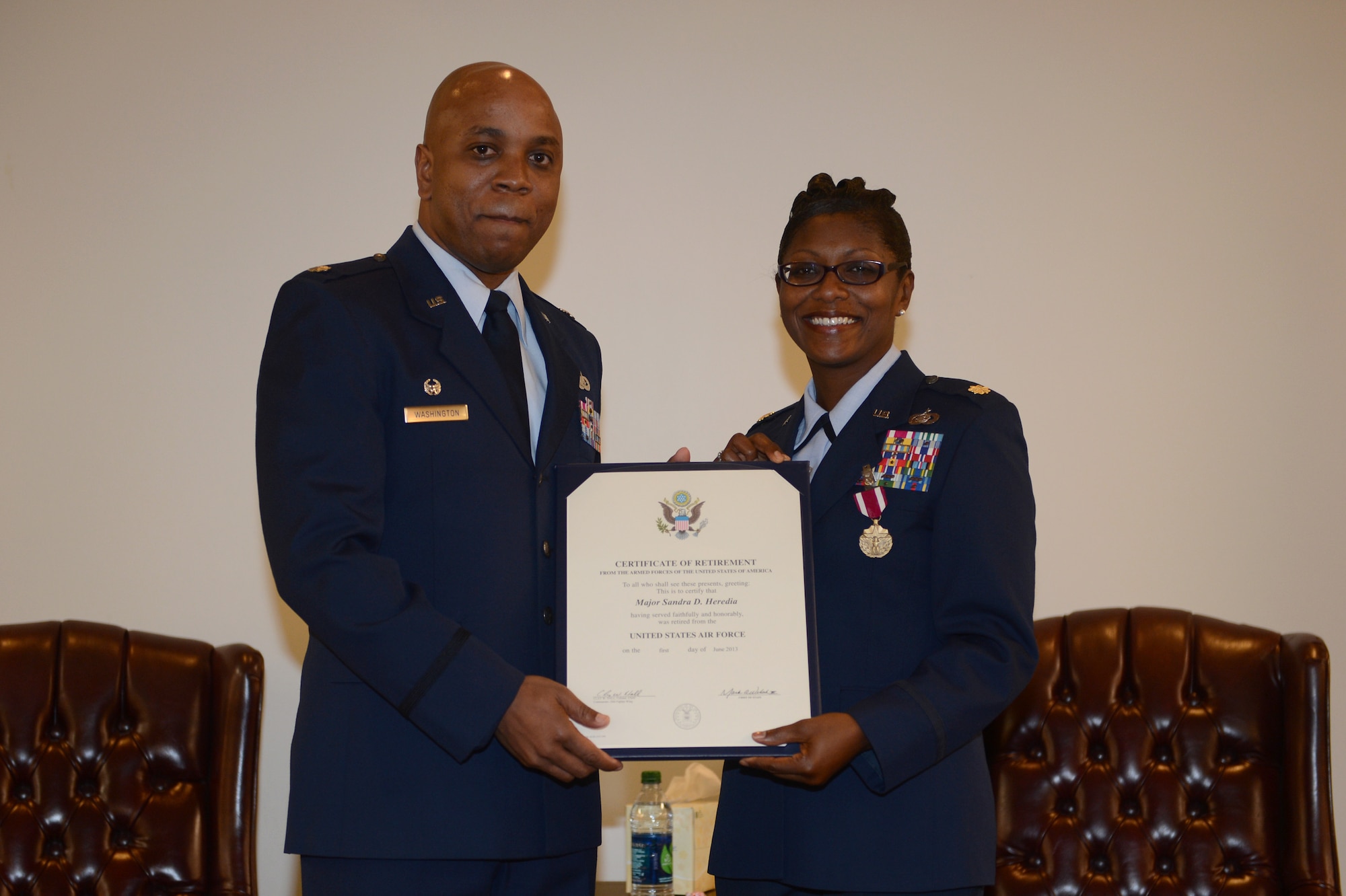 U.S. Air Force Lt. Col. Dalian Washington Sr., 20th Force Support Squadron commander, presents Maj. Sandra Heredia, 20th FSS director of operations, with her certificate of retirement after almost 30 years of service, Shaw Air Force Base, S.C., March 15, 2013. Heredia first enlisted in 1983 as an administrative specialist. She was commissioned in 2000 after receiving her master’s degree in management in 1999.
