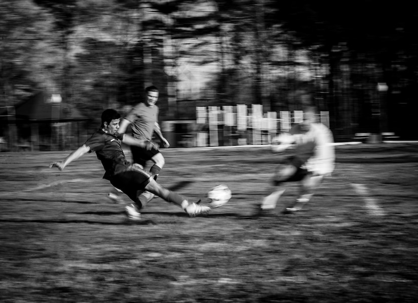 Mohammed Rezk, 437th Aircraft Maintenance Squadron intramural soccer team forward, performs a sliding kick while the 437th Aerial Port Squadron intramural soccer team goalie attempts to block the ball March 14, 2013, at the Joint Base Charleston – Air Base soccer fields. The 437th AMXS soccer team squeaked by the 437th APS soccer team in a 4 – 2 shootout win in Joint Base Charleston’s 2013 intramural soccer season opener. (U.S. Air Force photo/ Senior Airman Dennis Sloan) (U.S. Air Force photo/ Senior Airman Dennis Sloan)