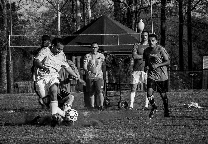 Nolan Jones, 437th Aerial Port Squadron intramural soccer team coach, is slide-tackled by a member of the 437th Aircraft Maintenance Squadron intramural soccer team during the first game of the season March 14, 2013, at the Joint Base Charleston – Air Base soccer fields. The 437th AMXS soccer team squeaked by the 437th APS soccer team in a 4 – 2 shootout win in Joint Base Charleston’s 2013 intramural soccer season opener. (U.S. Air Force photo/ Senior Airman Dennis Sloan)