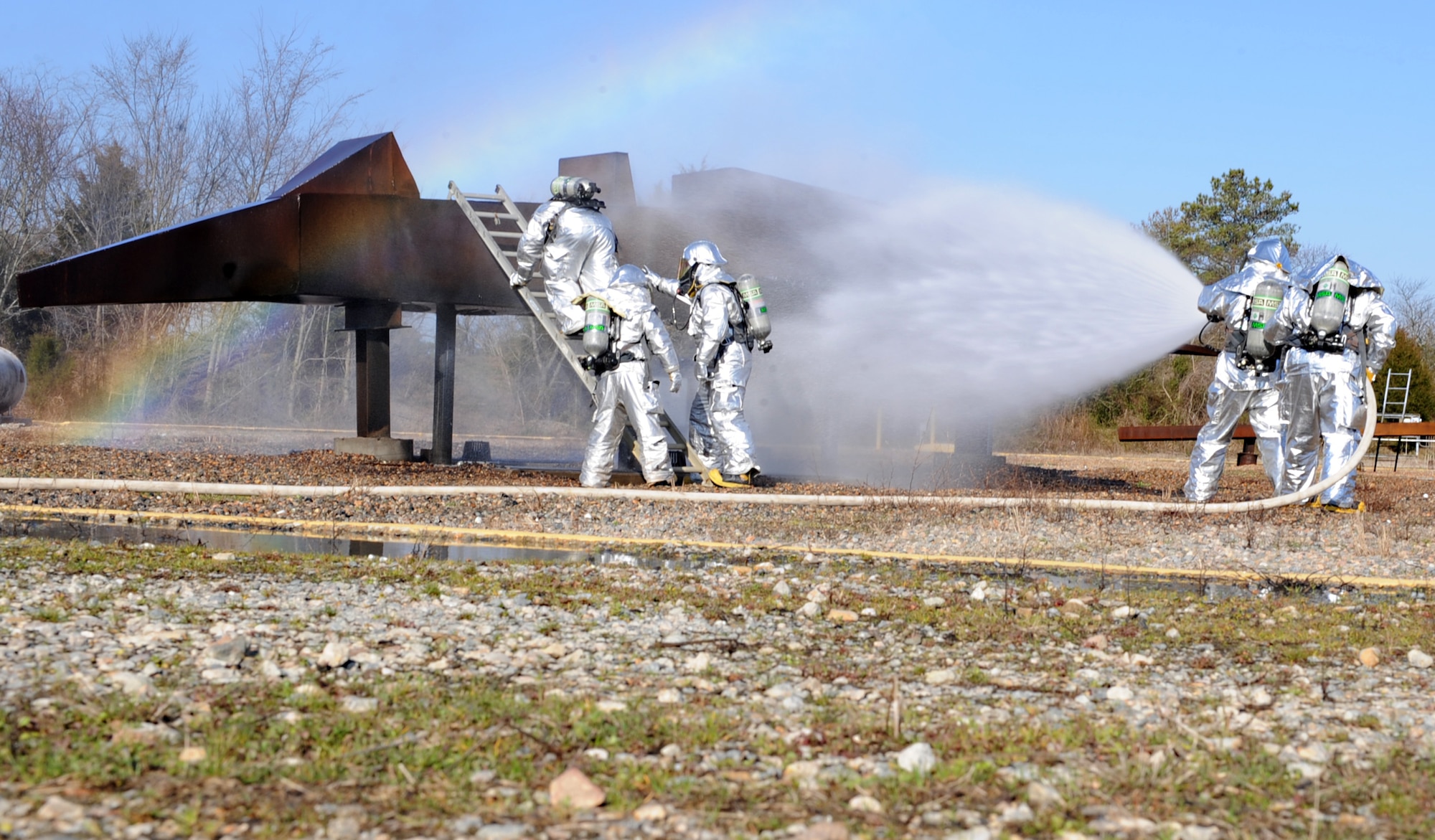 633rd Civil Engineering Squadron firefighters extinguish a fire during a training exercise at Langley Air Force Base, Va., Feb. 28, 2013. Burn-pit exercises are performed to ensure Airmen are prepared for a real-world fire. (U.S. Air Force photo by Senior Airman Brittany Paerschke-O’Brien/Released)