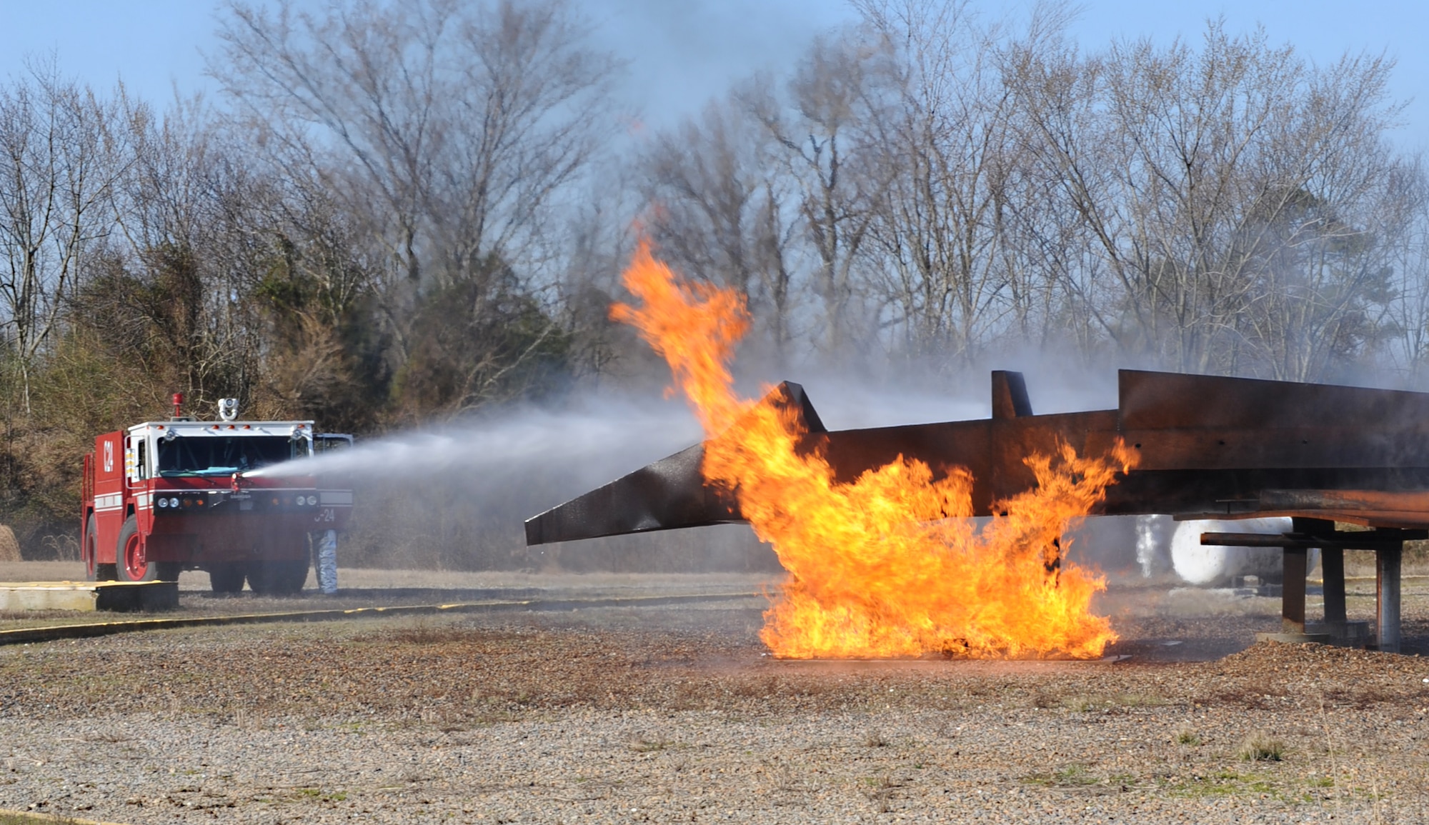 633rd Civil Engineering Squadron firefighters use a crash truck to smother a fire during a training exercise at Langley Air Force Base, Va., Feb. 28, 2013. Different types of aircraft require specific amount of water to put out a fire, and crash trucks are used because of their large capacity. (U.S. Air Force photo by Senior Airman Brittany Paerschke-O’Brien/Released)