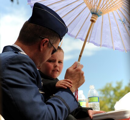 U.S. Air Force Col. Robert Haines, 9th Operations Group commander, and his son watch the Bok Kai Festival in Marysville, Calif., March 16, 2013. Beale Air Force Base’s Honor Guard and members of the 9th Reconnaissance Wing leadership marched in the parade. (U.S. Air Force photo by Staff Sgt. Robert M. Trujillo/Released) 
