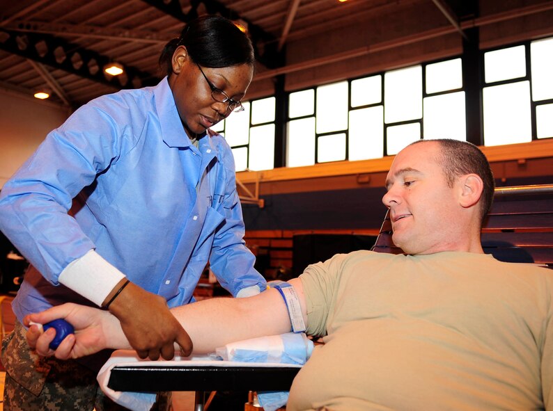 From left, Spc. Danielle Thrift, Armed Services Blood Program medical lab technician from Camden, S.C., prepares Tech. Sgt. Jason Doyle, 100th Civil Engineer Squadron emergency management craftsman from Franklin, Tenn., to donate March 19, 2013, at the blood drive on RAF Mildenhall, England. The blood drive was held as part of the mobile Armed Services Blood Program that allows service members, who do not live near an ASBP center, to donate. (U.S. Air Force photo by Senior Airman Ethan Morgan)