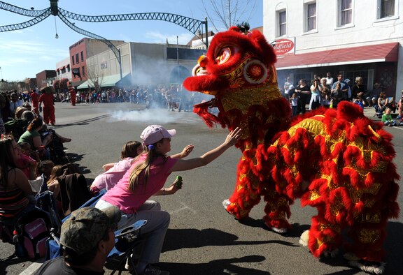 Parade spectators try to pet a lion dancer during the Bok Kai Festival in Marysville, Calif., March 16, 2013. Beale Air Force Base Honor Guard and members of the 9th Reconnaissance Wing leadership marched in the parade. (U.S. Air Force photo by Staff Sgt. Robert M. Trujillo/Released)