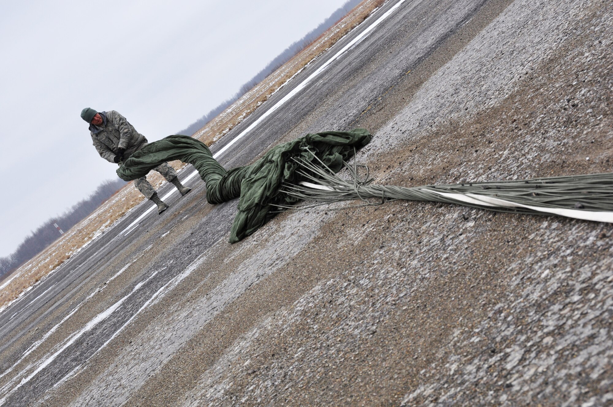 An Airmen from the 30th Aerial Port Squadron collects a parachute after a heavy equipment aerial drop exercise March 2, 2013 at the Niagara Falls Air Reserve Station, N.Y.  (U.S. Air Force photo by Staff Sgt. Stephanie Clark)