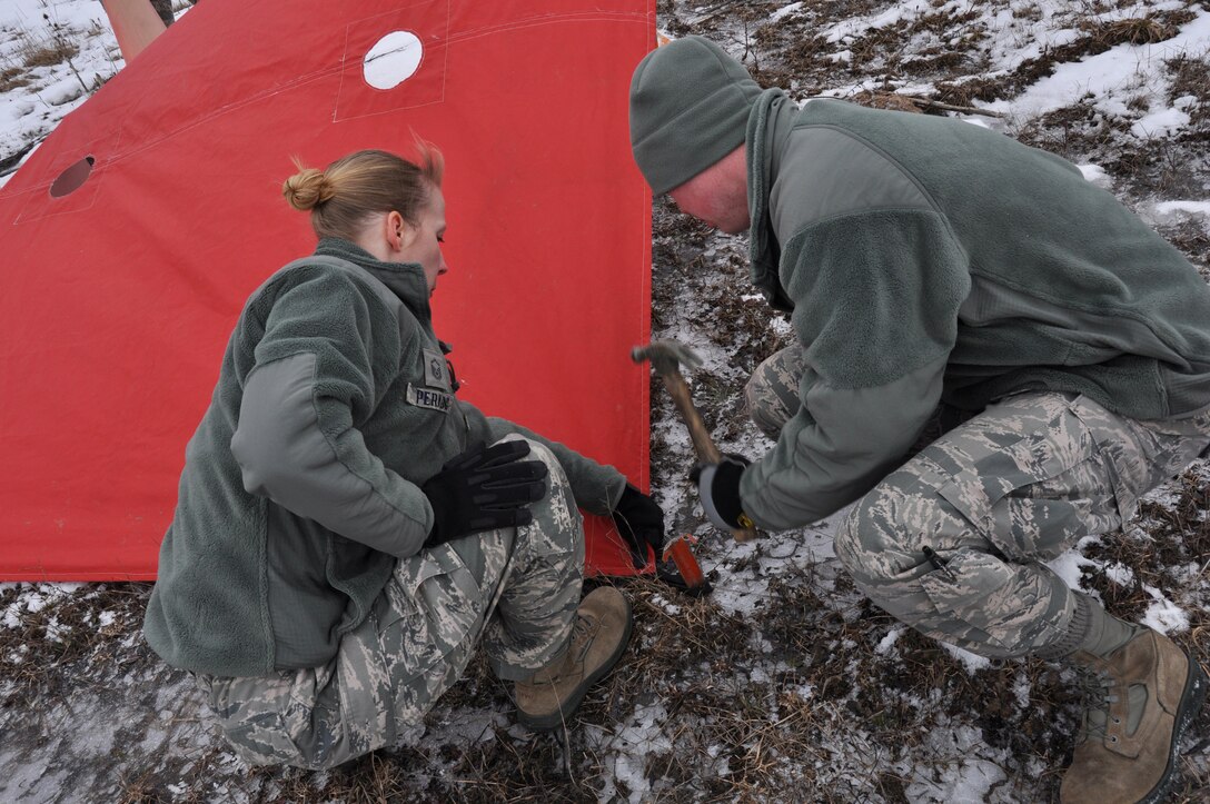 Two Airmen from the 30th Aerial Port Squadron tie down landing targets in preparation for heavy equipment aerial drops from a C-130 Hercules aircraft at the Niagara Falls Air Reserve Station, N.Y. March 2, 2013.  (U.S. Air Force photo by Staff Sgt. Stephanie Clark)
