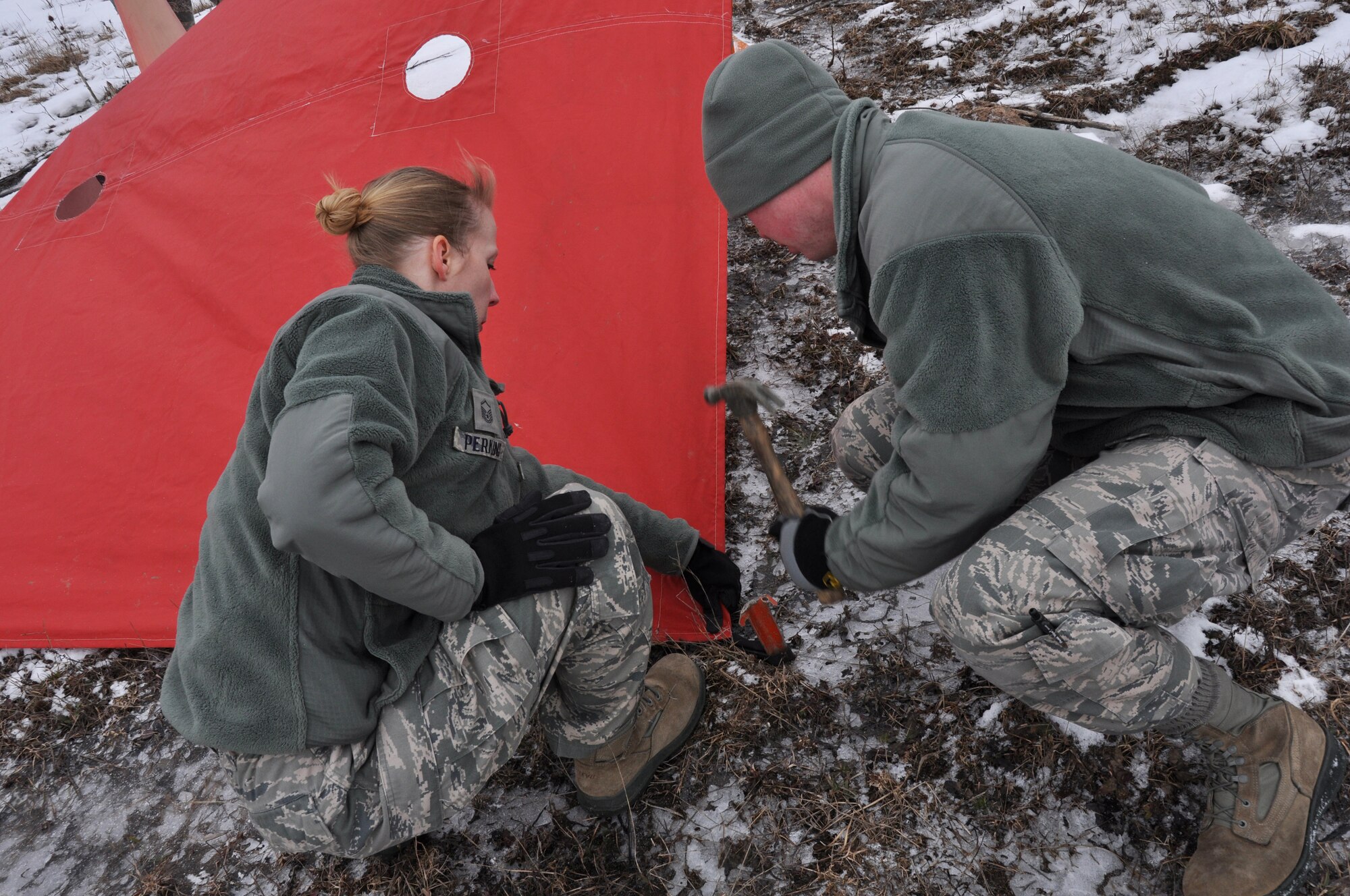 Two Airmen from the 30th Aerial Port Squadron tie down landing targets in preparation for heavy equipment aerial drops from a C-130 Hercules aircraft at the Niagara Falls Air Reserve Station, N.Y. March 2, 2013.  (U.S. Air Force photo by Staff Sgt. Stephanie Clark)