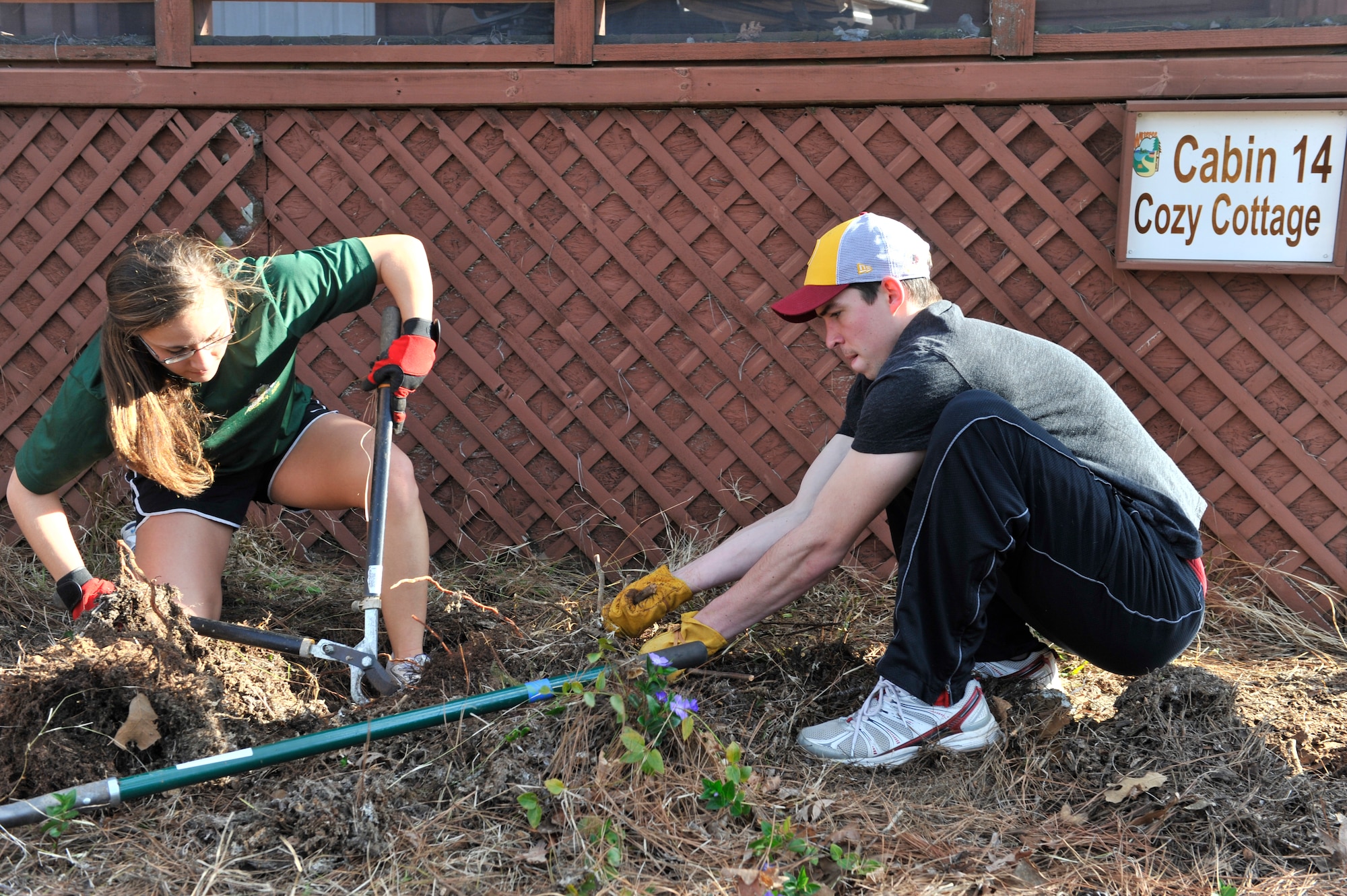 U.S. Air Force Airman 1st Class Hailey Garrett and Senior Airman Kyle Dorman, 28th Operational Weather Squadron weather forecaster apprentices, pull roots out of a flower bed during the fourth annual beautification day, at the Wateree Recreation Area, Camden, S.C., March 16, 2013. The Wateree Recreation Area is covers of 25 acres of land and about one mile of shore line. It hosts more than 50,000 people a year. Volunteers help its staff of five prepare grounds for visitors. (U.S. Air Force photo by Senior Airman Amber E. N. Jacobs/Released)