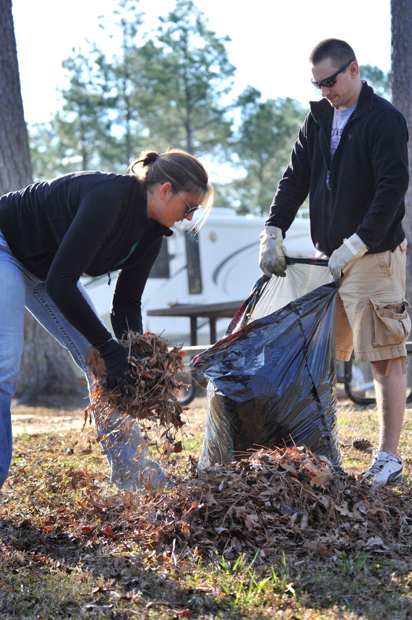 U.S. Air Force Airman 1st Class Bryan Norris and Senior Airman Alaina Deines, 20th Maintenance Operations Squadron maintenance management analysis data base managers, bag leaves and debris during the fourth annual beautification day, at the Wateree Recreation Area, Camden, S.C., March 16, 2013. Volunteers donated their time to clean the area before the beginning of the busy season. (U.S. Air Force photo by Senior Airman Amber E. N. Jacobs/Released)