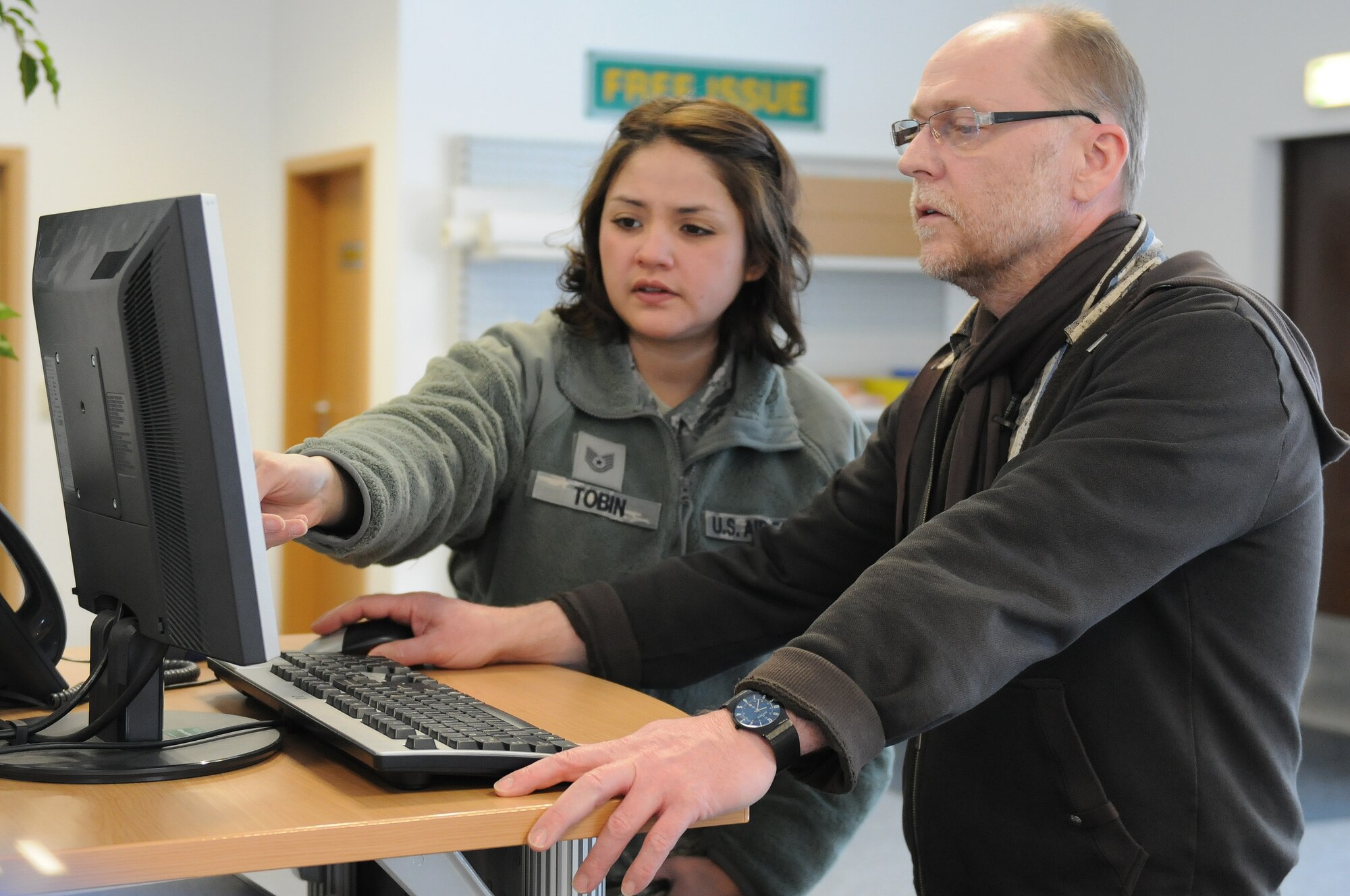 Holger Graf, civil engineer self-help store manager, assists Tech. Sgt. Claudia Tobin, United States Air Forces in Europe-Air Forces Africa Headquarters Air Communications clinical support technician, with the signing in process at the CE self-help store on Ramstein Air Base, Germany, March 15, 2013. The CE self-help store provides the base with their entire repair and clean up needs. (U.S. Air Force photo/Airman 1st Class Holly Cook)