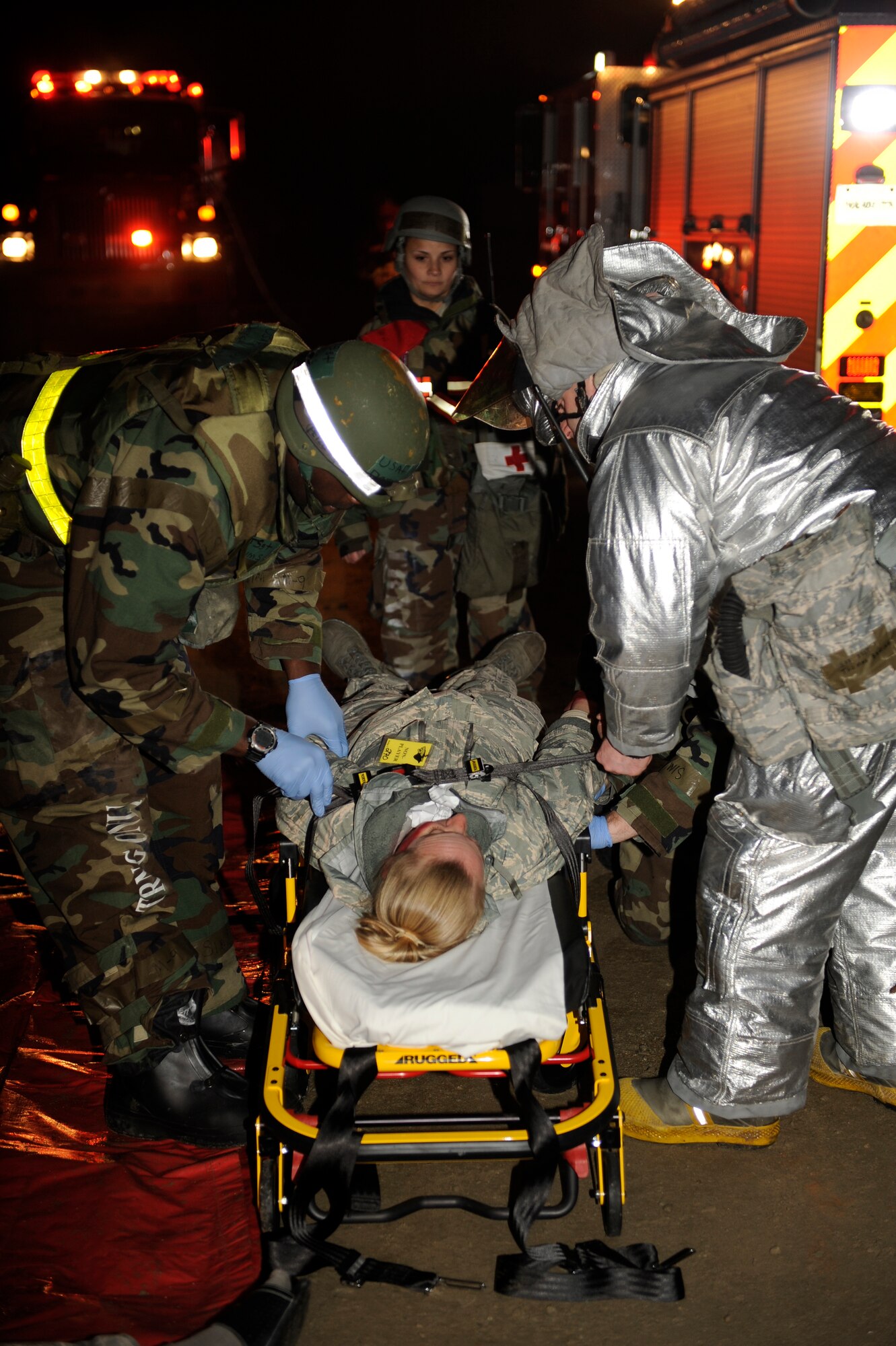 Tech. Sgt. Derrick Sims, left, 8th Medical Group, and Staff Sgt. Thomas Barina, 8th Civil Engineer Squadron, secure a role player onto a stretcher as Master Sgt. Jennifer Vargas, 8th Medical Operations Squadron exercise evaluation team member, observes their procedures during exercise Beverly Midnight 13-2 at Kunsan Air Base, Republic of Korea, Mar. 18, 2013. The scenario tested the unit’s ability to respond to and treat burn victims during a simulated fire. (U.S. Air Force photo by Senior Airman Marcus Morris/Released)