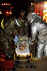 Tech. Sgt. Derrick Sims, left, 8th Medical Group, and Staff Sgt. Thomas Barina, 8th Civil Engineer Squadron, secure a role player onto a stretcher as Master Sgt. Jennifer Vargas, 8th Medical Operations Squadron exercise evaluation team member, observes their procedures during exercise Beverly Midnight 13-2 at Kunsan Air Base, Republic of Korea, Mar. 18, 2013. The scenario tested the unit’s ability to respond to and treat burn victims during a simulated fire. (U.S. Air Force photo by Senior Airman Marcus Morris/Released)