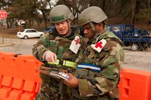 Staff Sgt. Brian Cummings, left, and Tech. Sgt. Emanuel Rodrigues, 8th Medical Support Squadron members, look up information on unexploded ordnance during exercise Beverly Midnight 13-2 at Kunsan Air Base, Republic of Korea, March 19, 2013. Cummings and Rodrigues were being assessed on their ability to properly call-in a UXO. (U.S. Air Force photo by Staff Sgt. Jonathan Fowler/Released)