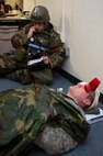 Staff Sgt. Charles Scarbrough, 8th Logistics Readiness Squadron, calls in information about wounds sustained by Senior Airman Kipp Baldwin, 8th Fighter Wing role player, during a training scenario at Kunsan Air Base, Republic of Korea, March 19, 2013. The scenario was assessing the ability of Scarbrough to properly treat Baldwin as well as call in all relevant information to his unit control center. (U.S. Air Force photo by Staff Sgt. Jonathan Fowler/Released)