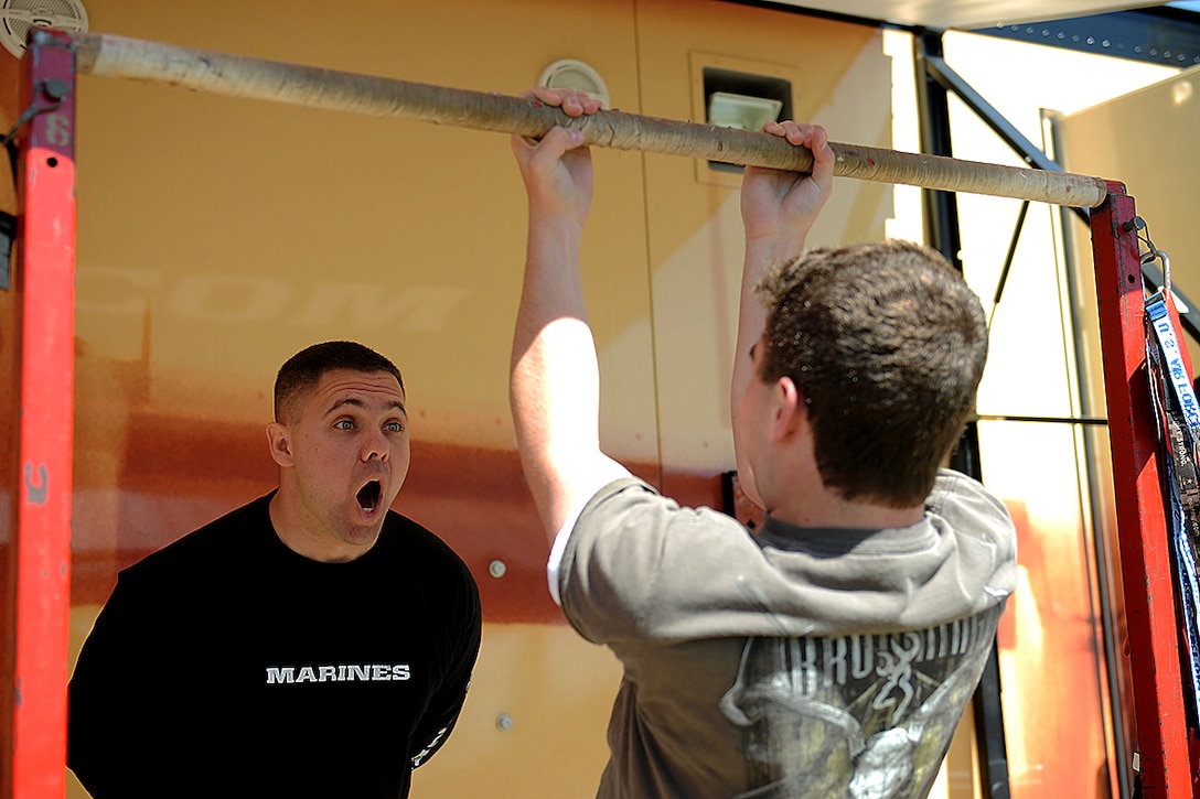 Sergeant Darrel Rich, Enhanced Marketing Vehicle Chief for 6th Marine Corps District and native of Tifton, Ga., motivates a student from Ouachita Parrish High School attempting to do pull ups in Monroe, La., during a recent high school visit to the school on March 14, 2013. Students of the Ouachita Parris High School were able to test how many pull ups they were able to do as well as check out the new Marine Corps recruiting trailer. (U.S. Marine Corps photo by Pfc. John-Paul Imbody)