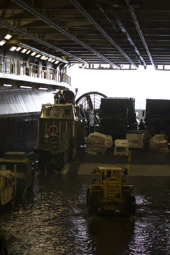 Marines assigned to the 26th Marine Expeditionary Unit (MEU) unload their gear and vehicles off of landing craft, air cushion vessels assigned to the USS Kearsarge (LHD 3), off the coast of Onslow Beach, N.C., March 13, 2013. The 26th MEU is deploying to the 5th Fleet and 6th Fleet areas of operation. The MEU operates continuously across the globe, providing the president and unified combatant commanders with a forward-deployed, sea-based, quick-reaction force. The MEU is a Marine Air-Ground Task Force capable of conducting amphibious operations, crisis-response and limited contingency operations. (U.S. Marine Corps photo by Cpl. Kyle N. Runnels/Released)
