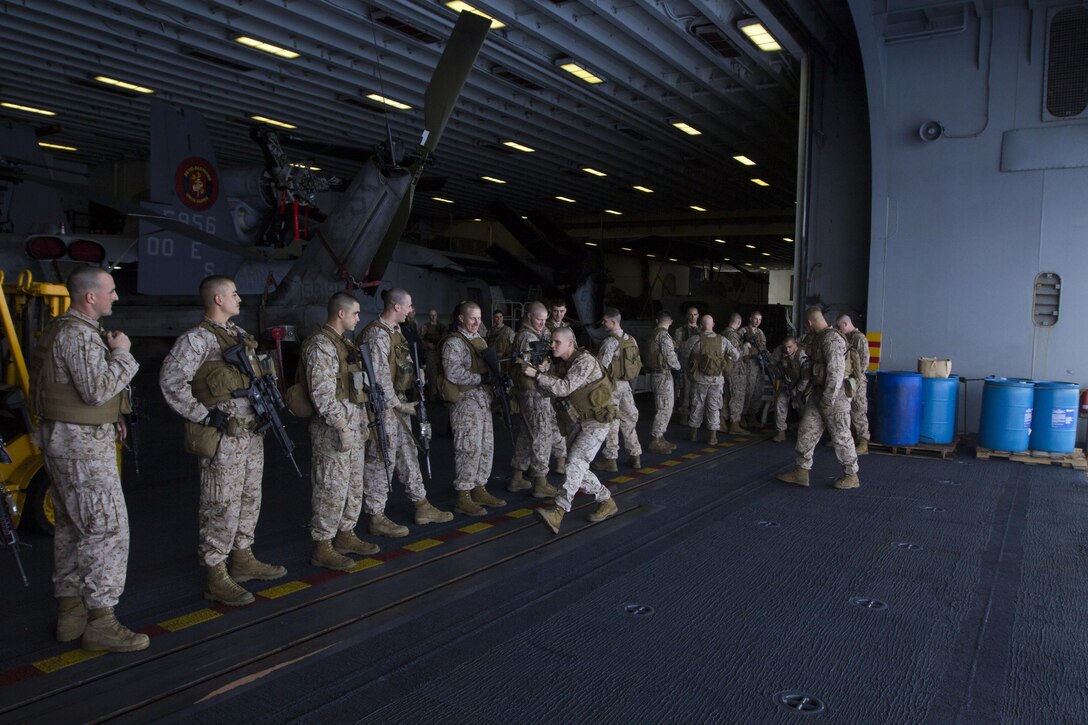 Marines and Sailors assigned to Battalion Landing Team 3/2, 26th Marine Expeditionary Unit (MEU), practice their combat manuevers in the hangar bay of the USS Kearsarge (LHD 3) while at sea March 18, 2013. The 26th MEU is deploying to the 5th Fleet and 6th Fleet areas of operation. The MEU operates continuously across the globe, providing the president and unified combatant commanders with a forward-deployed, sea-based, quick-reaction force. The MEU is a Marine Air-Ground Task Force capable of conducting amphibious operations, crisis-response and limited contingency operations. (U.S. Marine Corps photo by Cpl. Kyle N. Runnels/Released)