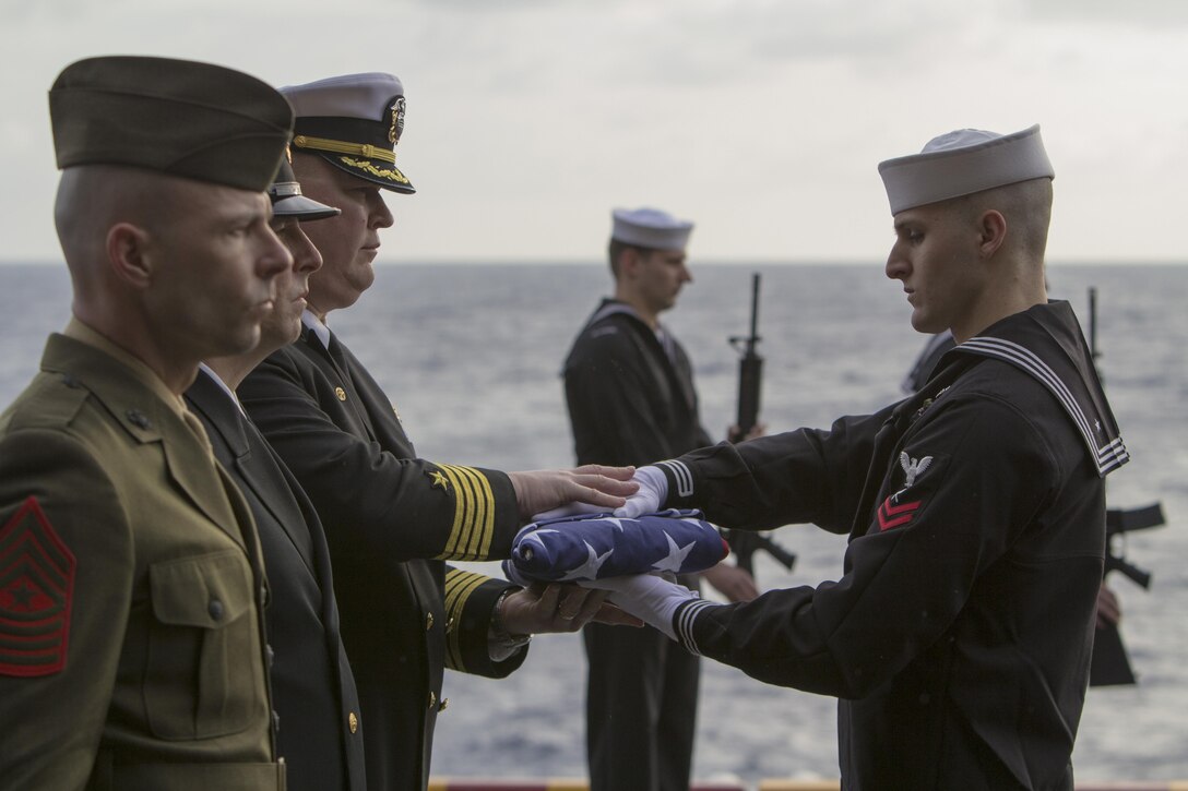 Marines assigned to the 26th Marine Expeditionary Unit and Sailors assigned to the USS Kearsarge (LHD 3) show their respects during a burial at sea ceremony while underway March 19, 2013. The 26th MEU is deploying to the 5th Fleet and 6th Fleet areas of operation. The MEU operates continuously across the globe, providing the president and unified combatant commanders with a forward-deployed, sea-based, quick-reaction force. The MEU is a Marine Air-Ground Task Force capable of conducting amphibious operations, crisis-response and limited contingency operations. (U.S. Marine Corps photo by Cpl. Kyle N. Runnels/Released)