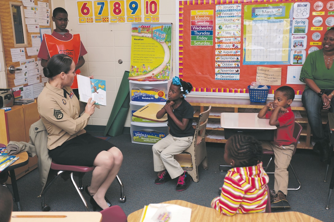 Staff Sgt. Juana L. De Los Santos, equal opportunity advisor for Marine Corps Logistics Command reads a book to a class full of students during Read Across America day Mar. 1. The NEA began the event Mar. 2, 1998 and is meant as a celebration which will further inspire students to read throughout the year. In Albany, Marines took part in the event volunteering their time at local schools. (U.S. Marine Corps photo by Sgt. Brandon L. Saunders/released)