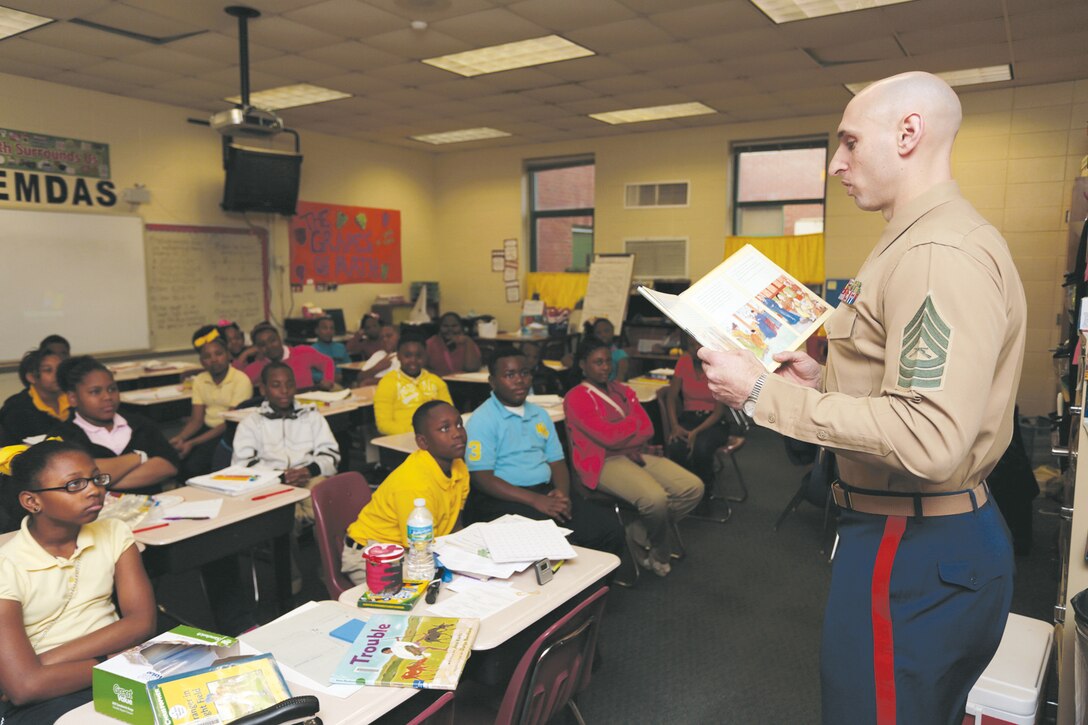 ALBANY, GA -- Master Sgt. Jason E. Spangenberg, career planner for Marine Corps Logistics Command reads a book to a class full of students during Read Across America day Mar. 1. The NEA began the event Mar. 2, 1998 and is meant as a celebration which will further inspire students to read throughout the year. In Albany, Marines took part in the event volunteering their time at local schools. (U.S. Marine Corps photo by Sgt. Brandon L. Saunders/released)