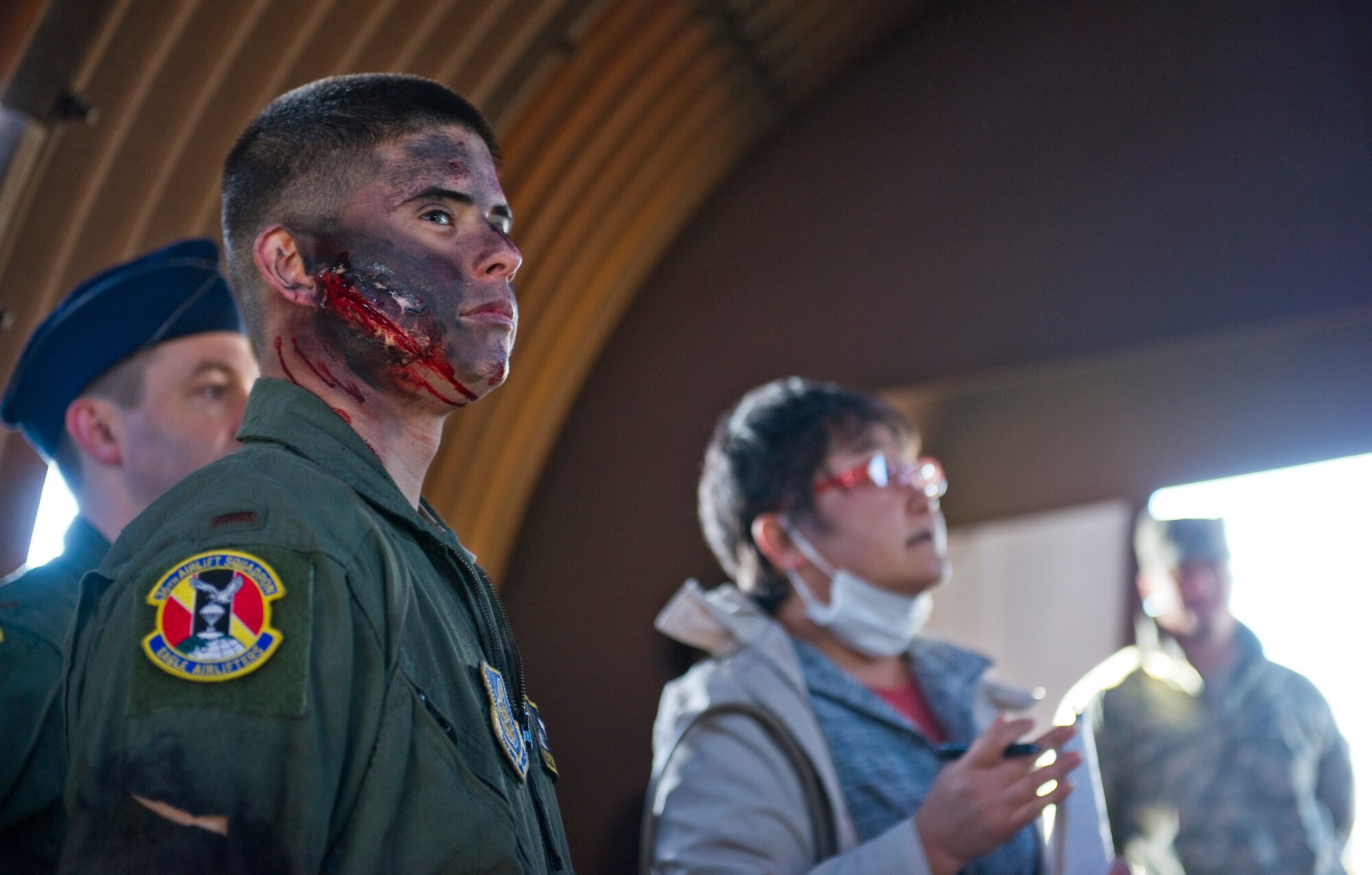 YOKOTA AIR BASE, Japan -- Airman 1st Class Paul Hensley, 36th Airlift Squadron loadmaster, waits for instruction prior to an emergency management exercise at Yokota Air Base, Japan, Mar. 21, 2013. Hensley role-played being an injured pilot after crashing during the exercise. (U.S. Air Force photo by SSgt Chad C. Strohmeyer)