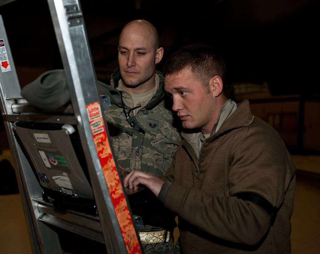 Staff Sgt. Michael Overall, 28th Maintenance Group quality assurance inspector, observes as Senior Airman Brandon Wilkins, 28th Aircraft Maintenance Squadron B-1 crew chief, reviews technical orders while greasing a B-1 actuator during an Operational Readiness Exercise at Ellsworth Air Force, S.D., March 20, 2013. The quality assurance section inspects tasks performed during the ORE to ensure aircraft are mission ready. (U.S. Air Force photo by Airman 1st Class Alystria Maurer/Released)