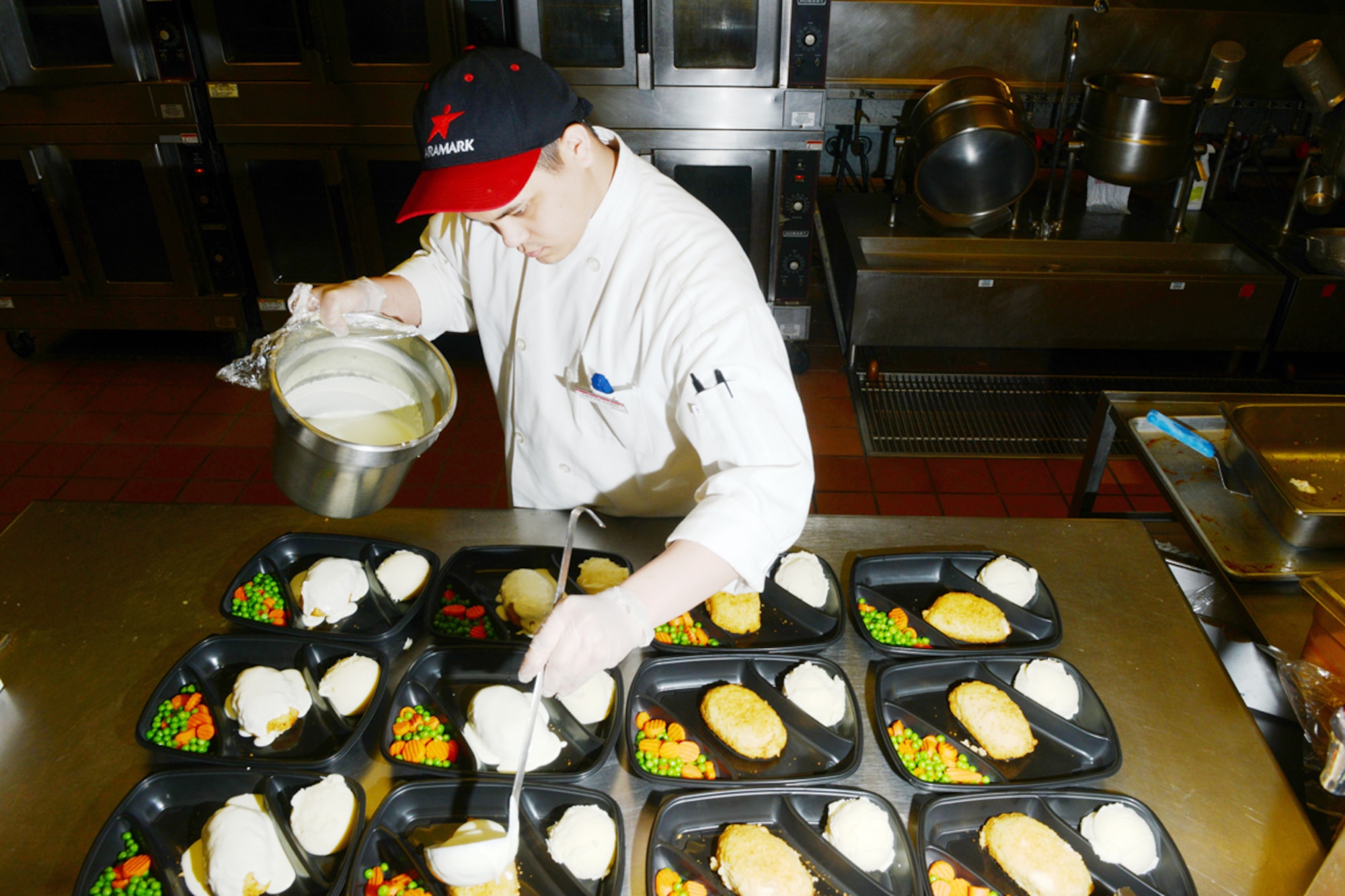 Gavyn Yaris, an Aramark employee, prepares meals for the Provisions on Demand facility at the Iditarod facility March 9. The Iditarod dining facility is one of four Air Force-wide dining facilities a part of the Food Transformation Initiative. The FTI is a pilot program designed to provide Airmen with improved food quality. (U.S. Air Force photo/Airman Ty-Rico Lea)