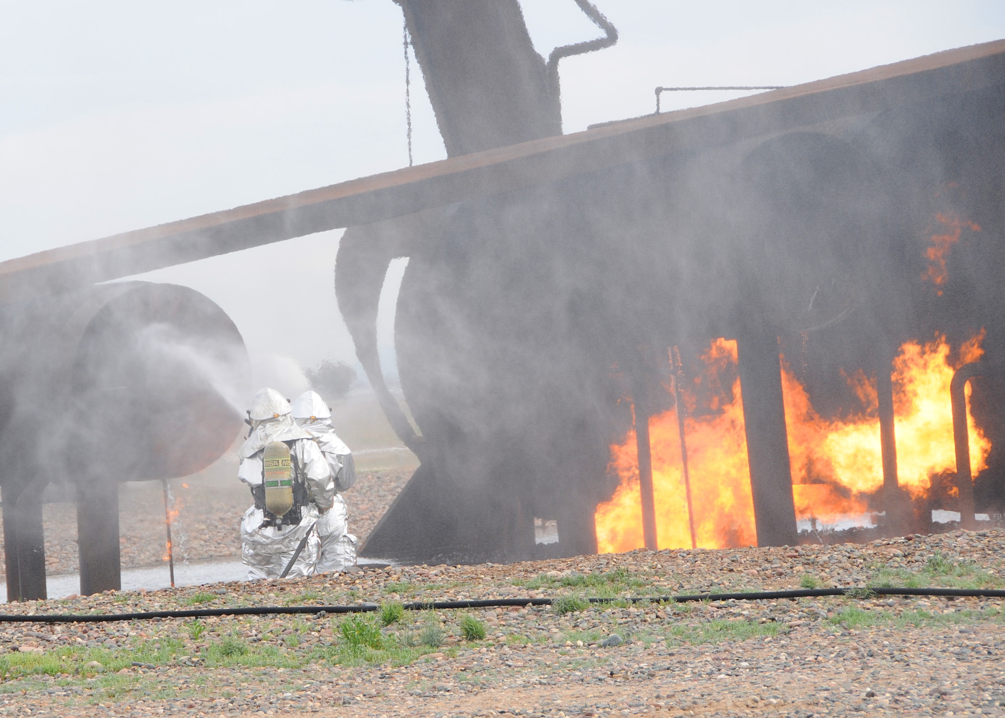 Two firefighters from the 944th Civil Engineer Squadron work together to put out an aircraft fire March 3 during annual live fire training. (U.S. Air Force photo by Tech. Sgt. Louis Vega Jr.)
