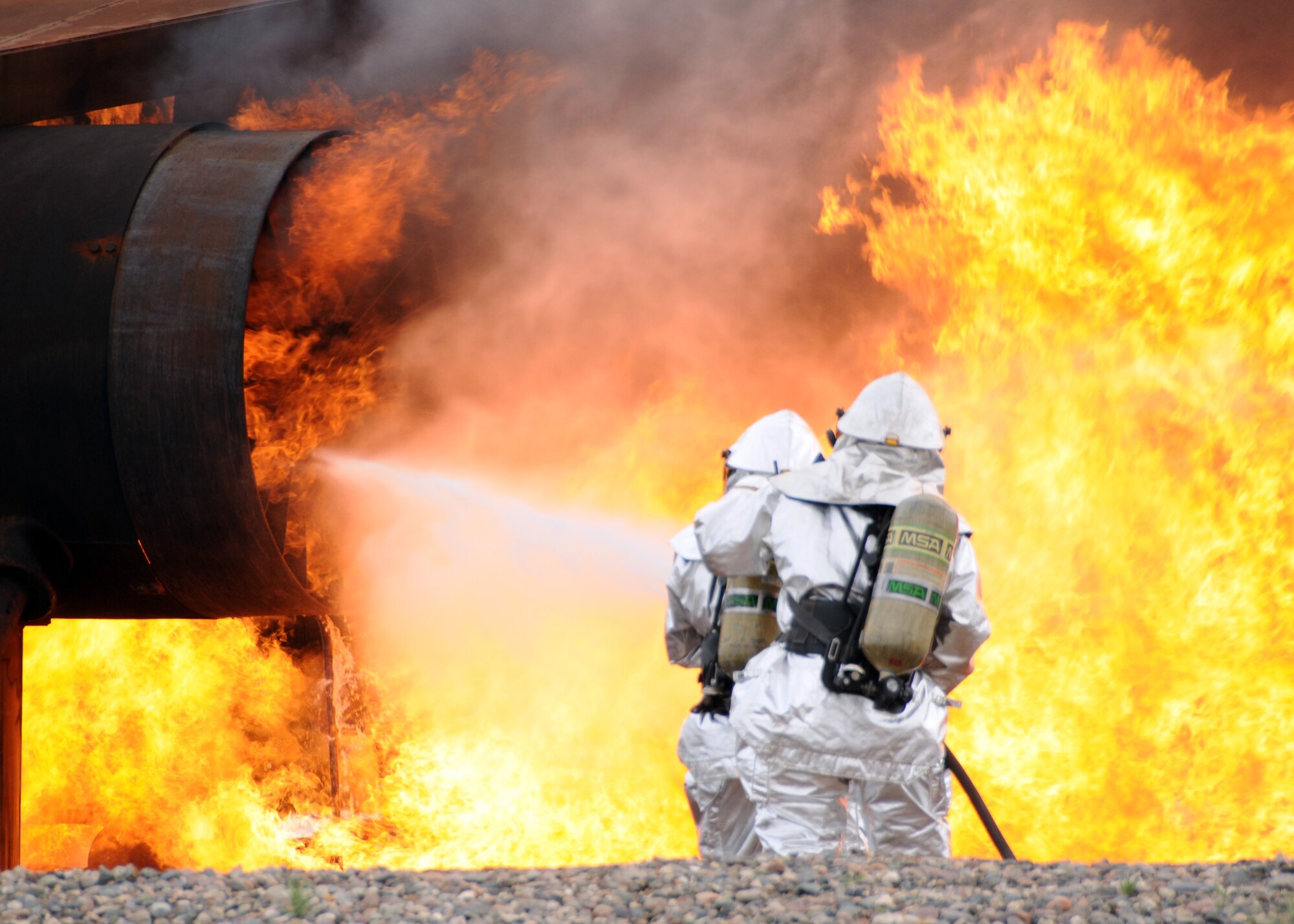 Two firefighters from the 944th Civil Engineer Squadron work together to put out an aircraft fire March 3 during annual live fire training. (U.S. Air Force photo by Tech. Sgt. Louis Vega Jr.)