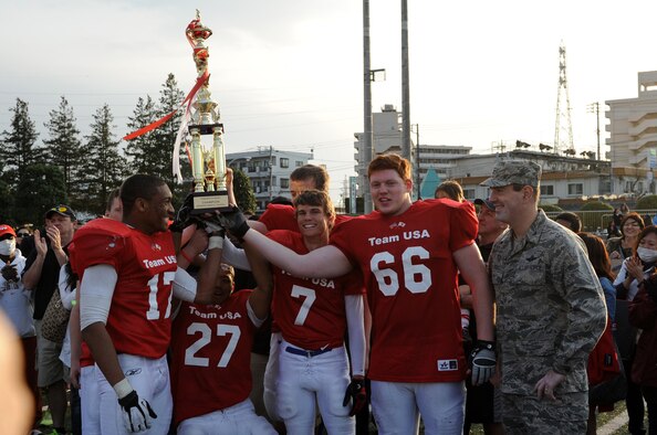  Col. Mark August, 374th Airlift Wing commander, and Team USA captains hold up their trophy following the 2013 Tomodachi Bowl March 10, 2013, Yokota Air Base, Japan. Team USA won the second annual bowl game 57 - 21. (U.S. Air Force photo/ Airman 1st Class Desiree Economides) 

