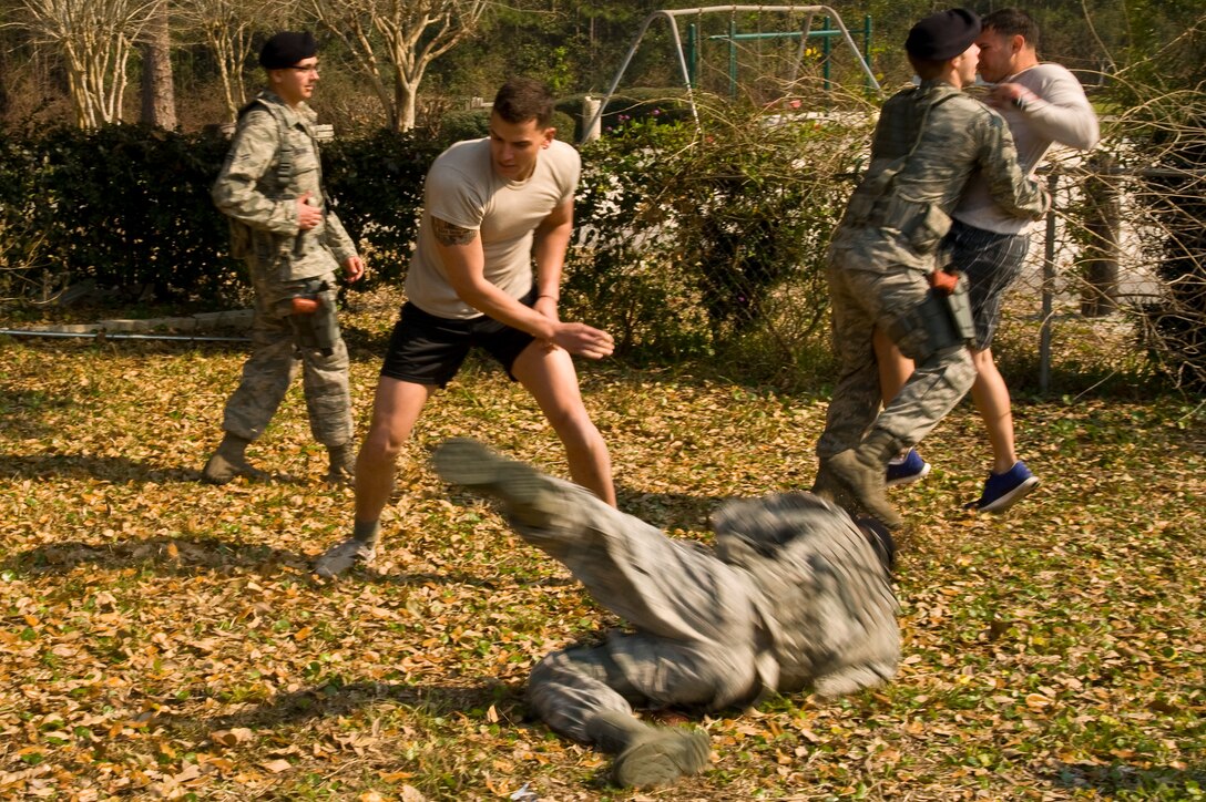 U.S. Air Force security forces members engage in a struggle with volunteer role players who were involved in a simulated brawl during domestic violence training conducted in base housing on Hurlburt Field, Fla., March 14, 2013. The afternoon was dedicated to getting security forces to put their classroom training into action by responding to challenging domestic violence scenarios. (U.S. Air Force photo by Airman 1st Class Michelle Vickers)