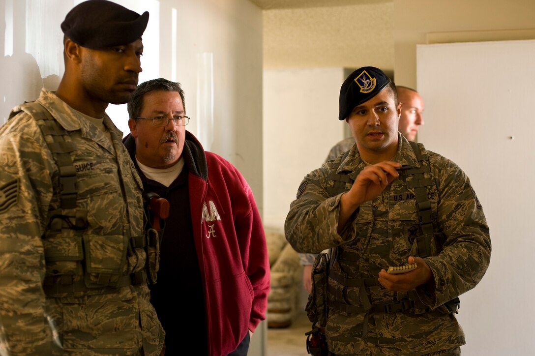 U.S. Air Force Staff Sgt. Cody Schwarz, a patrolman of 1st Special Operations Security Forces Squadron, relays information about a domestic violence incident to Tech. Sgt. Pharaoh Guice, a flight sergeant of 1st SOSFS, during domestic violence training at base housing on Hurlburt Field, Fla., March 14, 2013. Every element of responding to a domestic incident is put to the test during training including communication skills that can lead to a successful investigation. (U.S. Air Force photo by Airman 1st Class Michelle Vickers)
